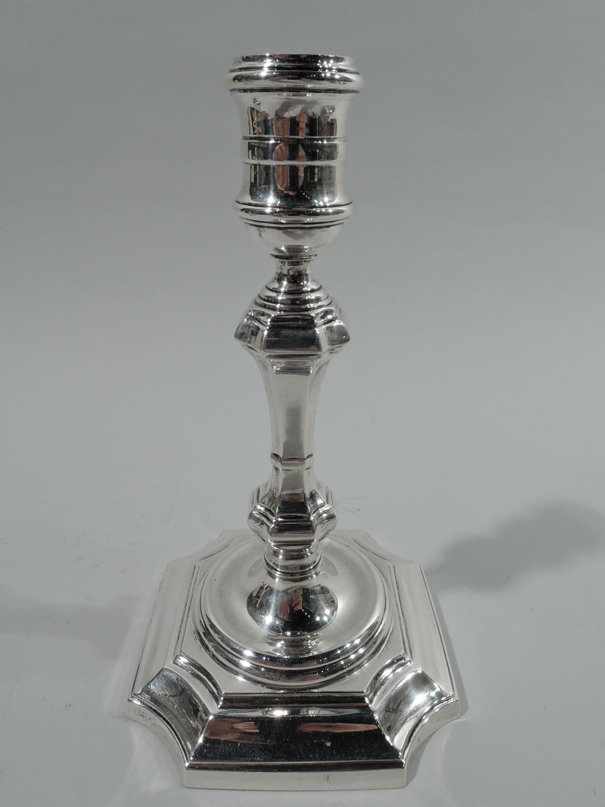Pair of Georgian-style sterling silver candlesticks. Made by Currier & Roby in New York, ca 1920. Each: Girdles spool socket mounted to faceted and knopped pillar; concave square base with depressed round center. Traditional table lighting in