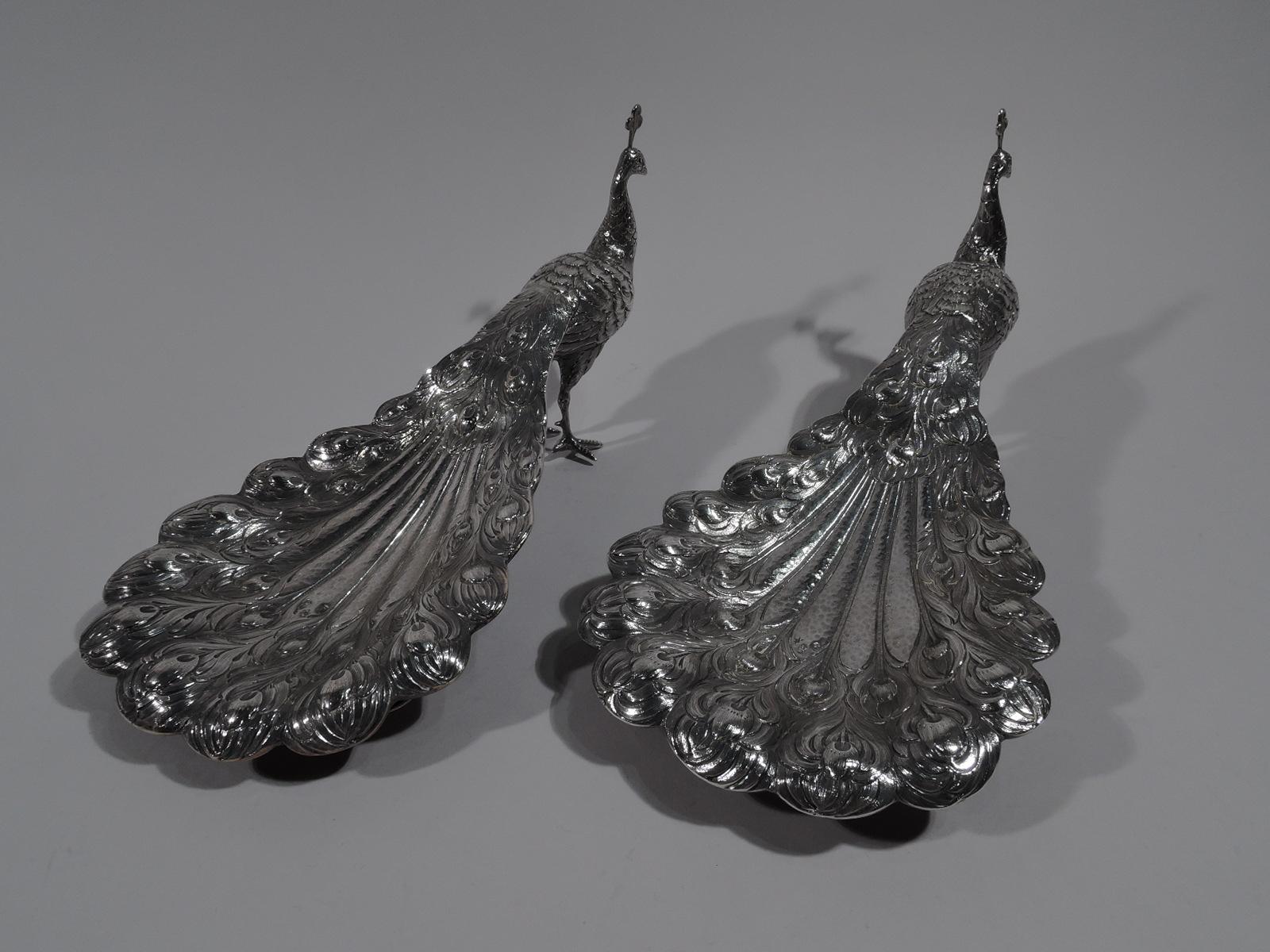 Pair of turn-of-the-century German 800 silver peacocks. Each: Downy body, scaly talons, and erect head with crest. Flamboyant downed tails are hollow for holding treats at your next dinner party. They’re boy birds—a welcome addition to the guest
