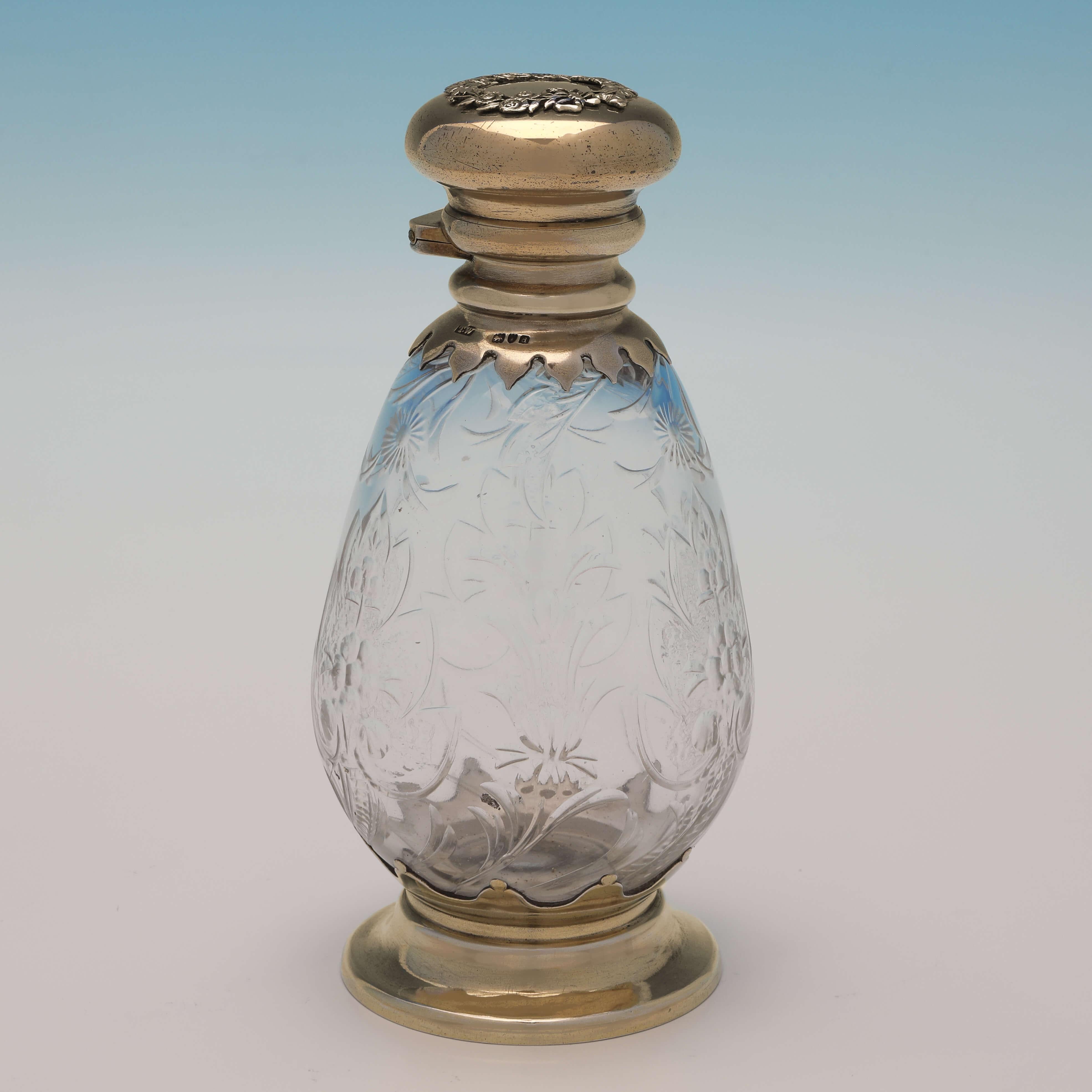 Hallmarked in London in 1899 by Thomas Whitehouse, this very attractive pair of Victorian, Antique Sterling Silver Scent Bottles, feature etched glass, and gilt silver tops and bases. Each scent bottle measures 6