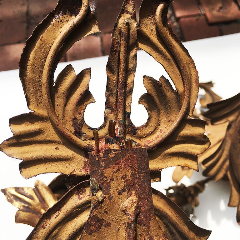 Matched pair of antique gilded applique tole 3-arm sconces. Beautiful curving acanthus-leaf forms and soft gold with patina. These were electrified at one point, wires are still in place, but were cropped close to the back of the fixture, and close
