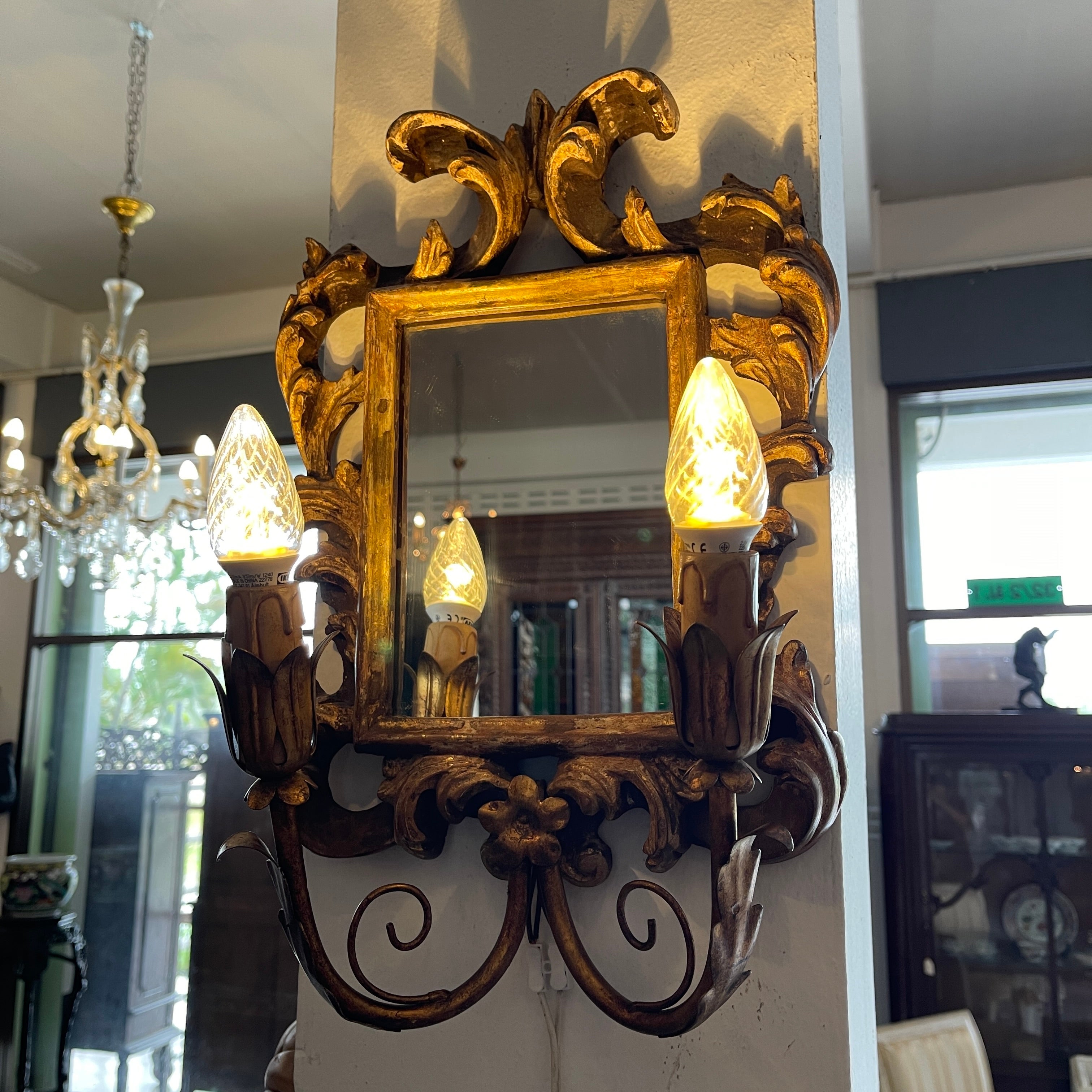 Presenting a stunning pair of 19th century Antique European giltwood carved mirror sconces. These exquisite sconces showcase the epitome of 19th-century craftsmanship, featuring intricately carved giltwood frames adorned with ornate motifs and