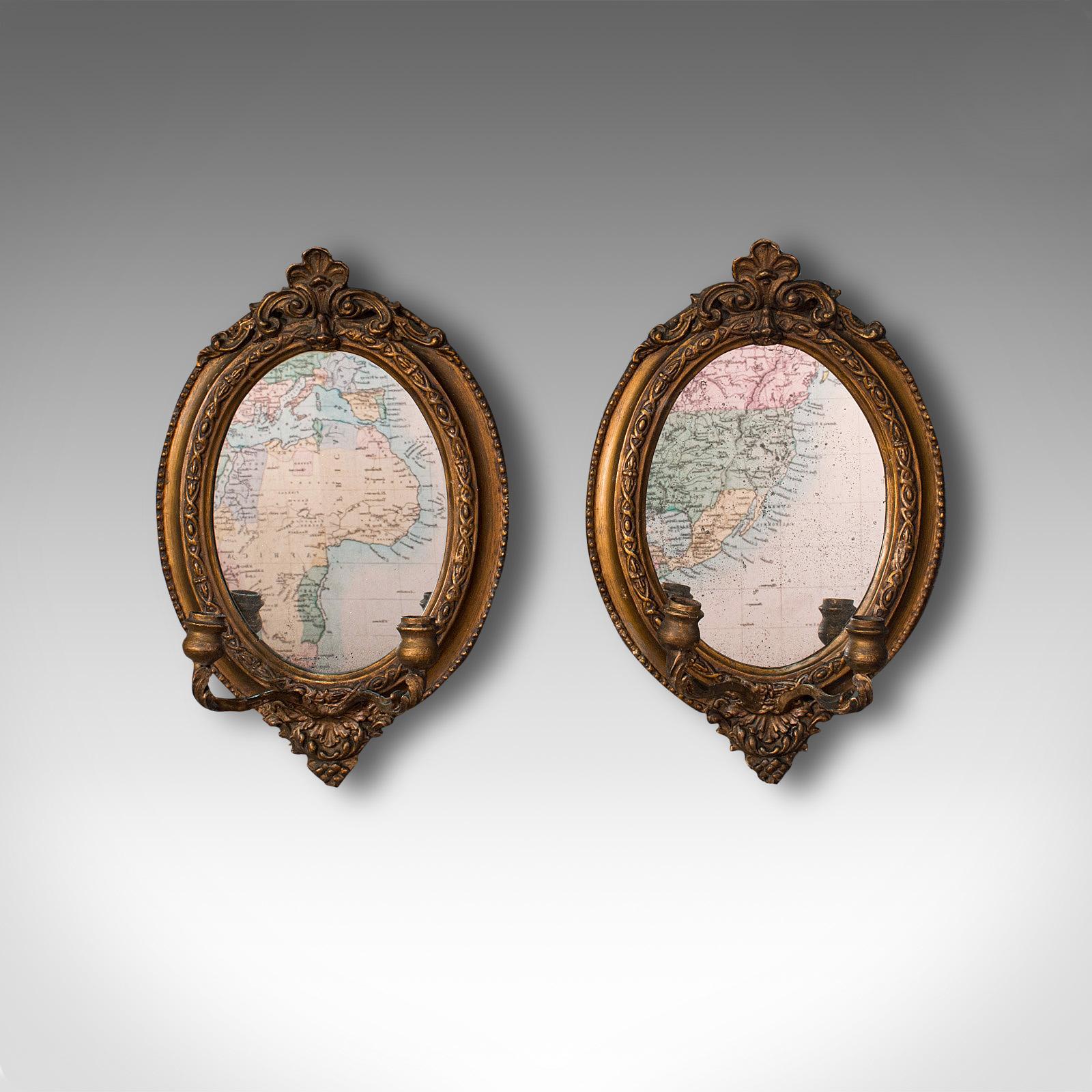 This is a delightful pair of antique girandole mirrors. An English, giltwood oval wall mirror with mercury plates, dating to the Regency period, circa 1820.

Striking examples offering warm colour and superb Regency taste
Displaying a desirable