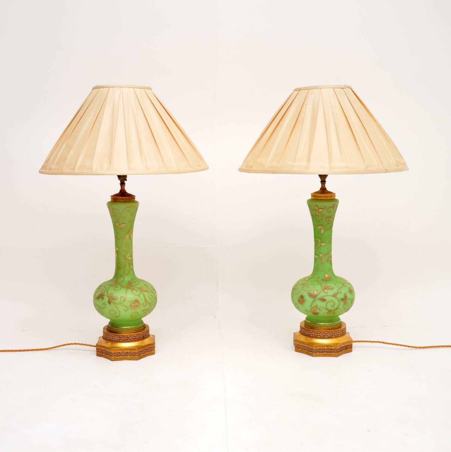 Une exquise paire de lampes de table antiques en verre et en métal doré, avec un superbe verre vert. Fabriqués en Angleterre, ils datent d'environ 1890-1900.

La qualité est exceptionnelle, le verre vert a la plus belle couleur et présente de