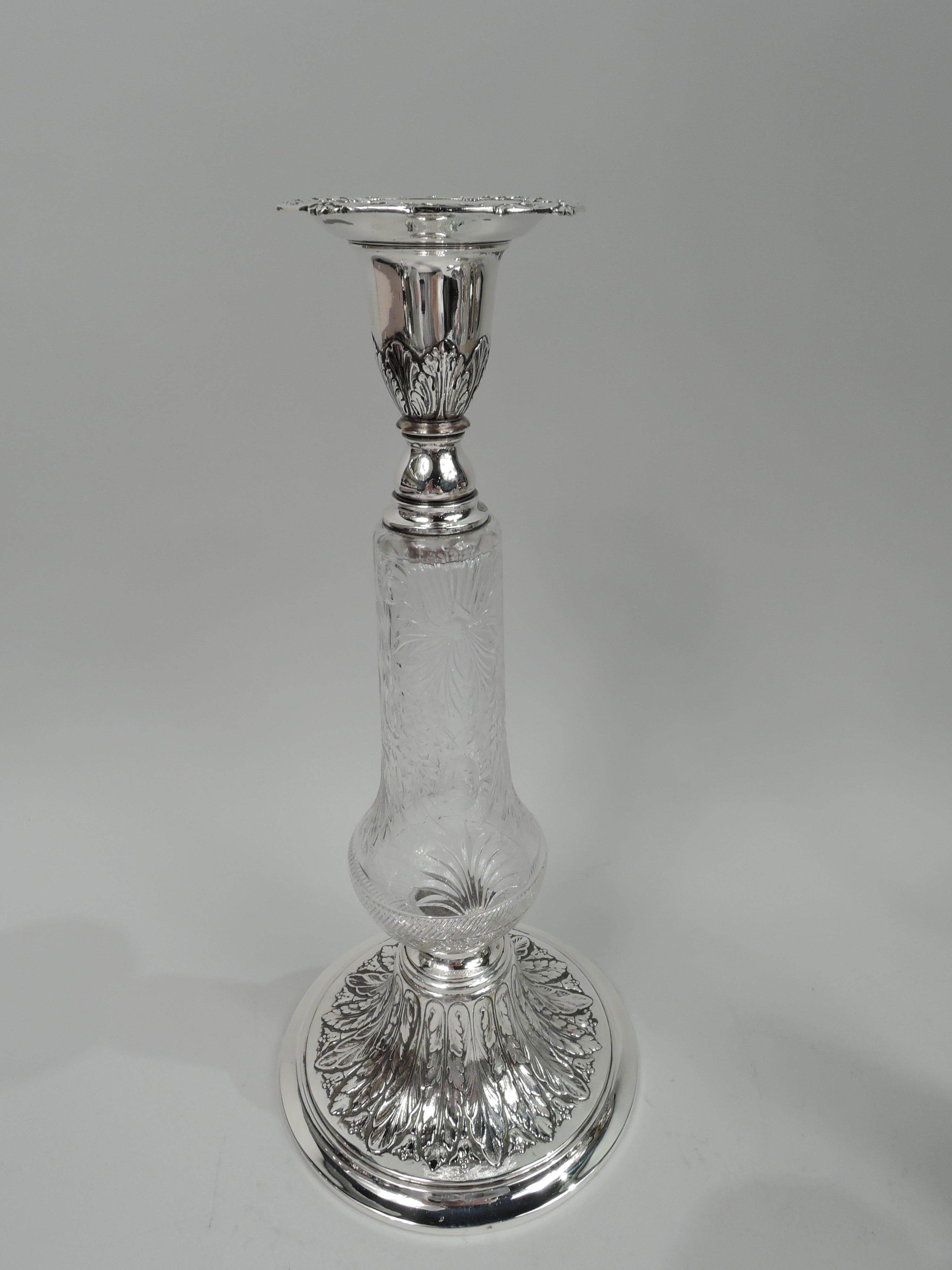 Pair of Edwardian classical candlesticks. Made by Gorham in Providence in 1929. Crystal baluster shaft with flowers, leaves, and diaper. Sterling silver socket with acanthus leaf ornament; detachable bobeche with scroll and imbricated leaf border.