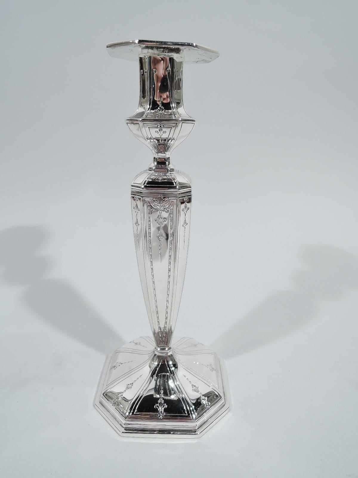 Pair of Edwardian Regency sterling silver candlesticks. Made by Durgin (part of Gorham) in Concord, New Hampshire, circa 1915. Pillar shaft on raised square base. Campana urn socket and detachable square bobeche. Faceting. Engraved leaf and pendant
