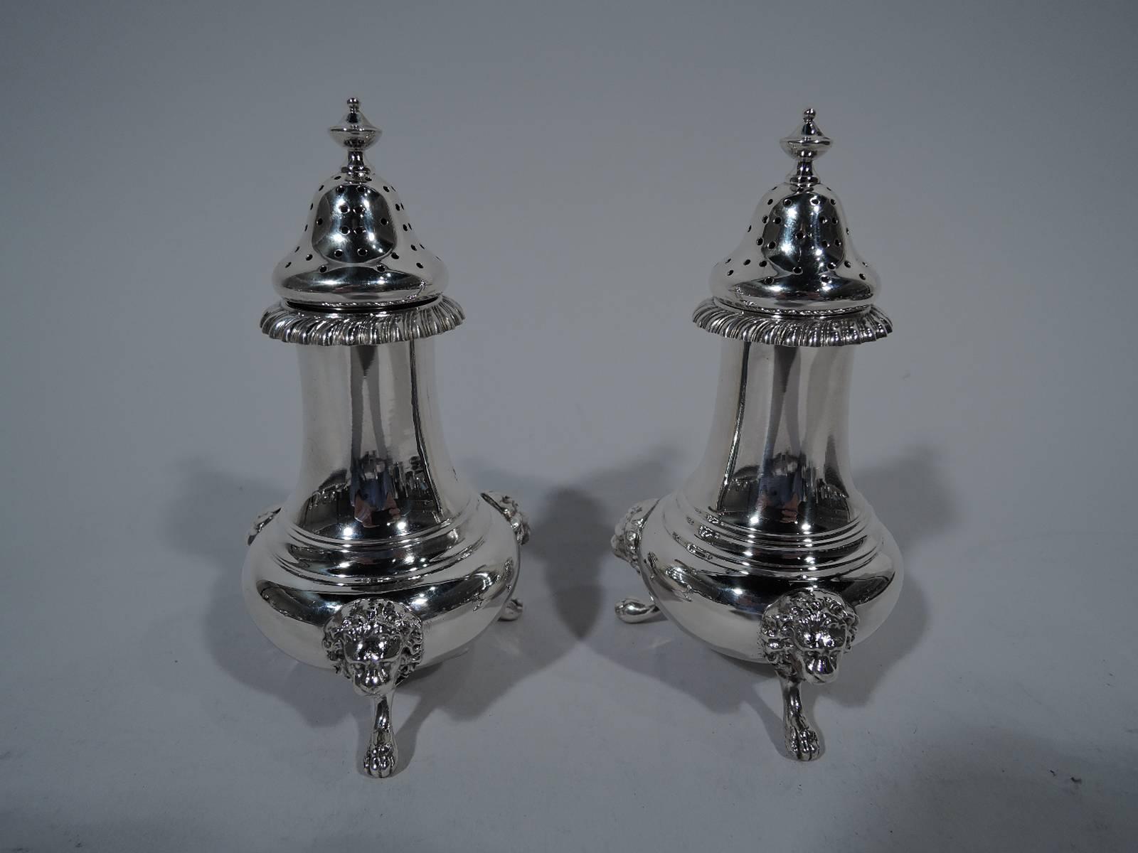 Pair of antique Neoclassical sterling silver salt & pepper shakers. Made by Gorham in Providence. Each: Baluster body supported by three lion monopodia. Turned-down and gadrooned rim and pierced domed cover with vase finial. Hallmark includes no.
