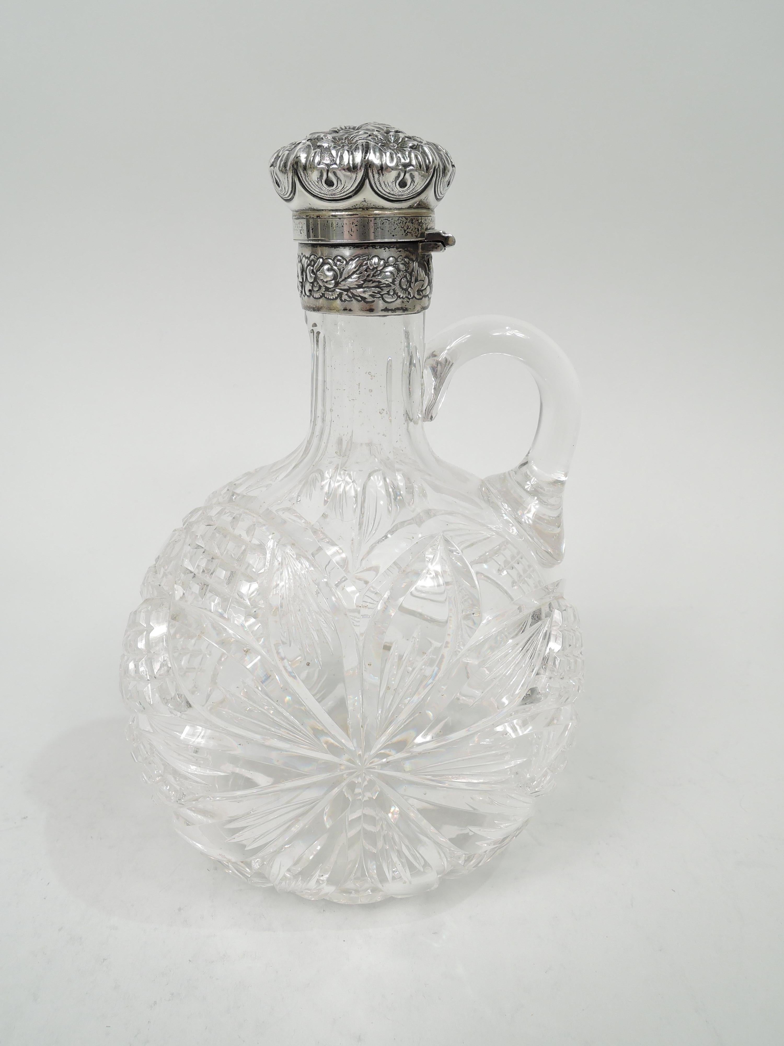 Pair of Victorian cut-glass and sterling silver decanters. Made by Gorham in providence in 1891. Each: moon body with large stylized flower head on both sides and diaper and stars on front and back. C-scroll handle mounted to shoulder and