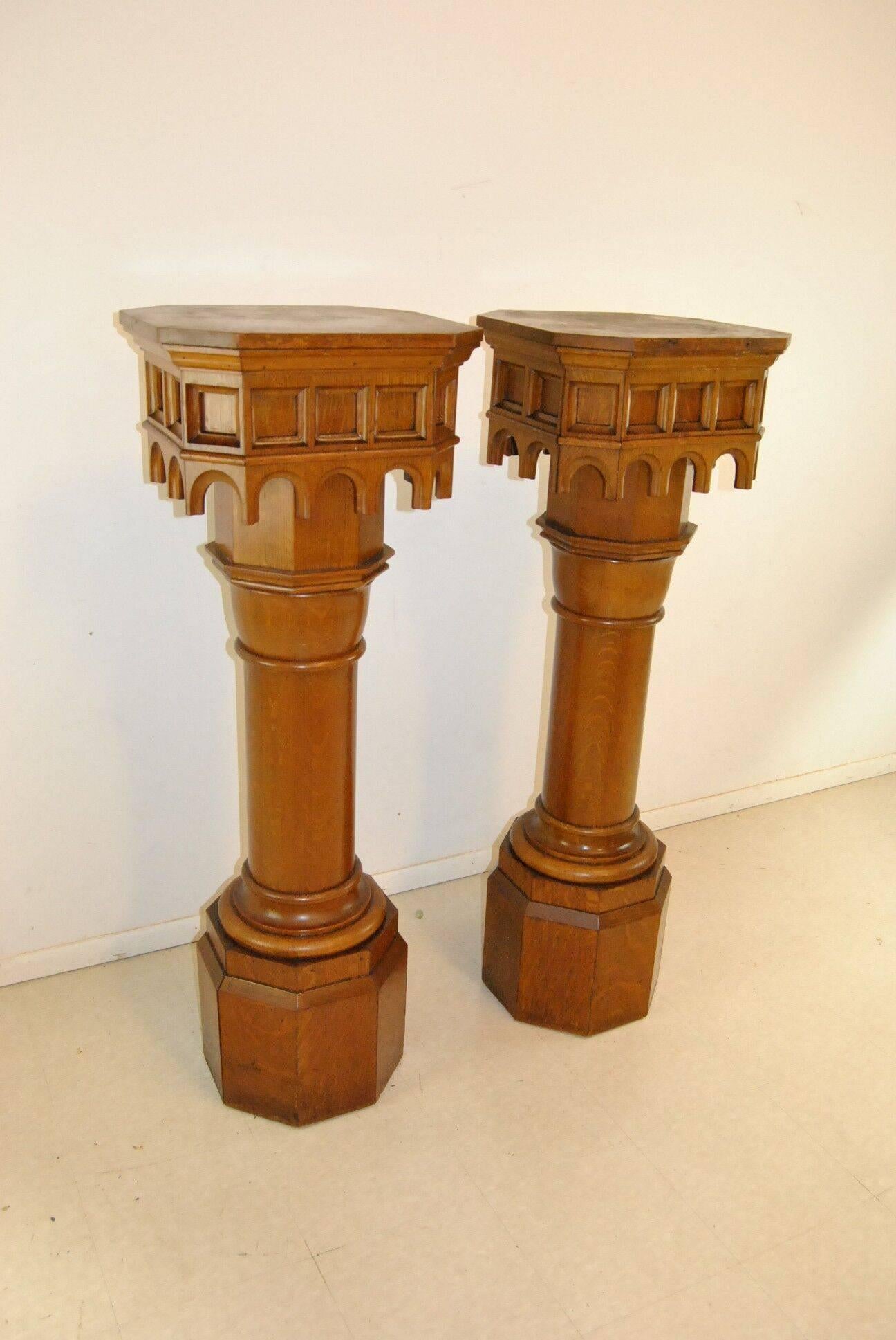 A beautiful pair of Gothic style pedestals done in quarter swan oak. The tops have an octagonal style design and a beautiful carved skirt surrounding them. They are solid oak and very well made. The dimensions are 19