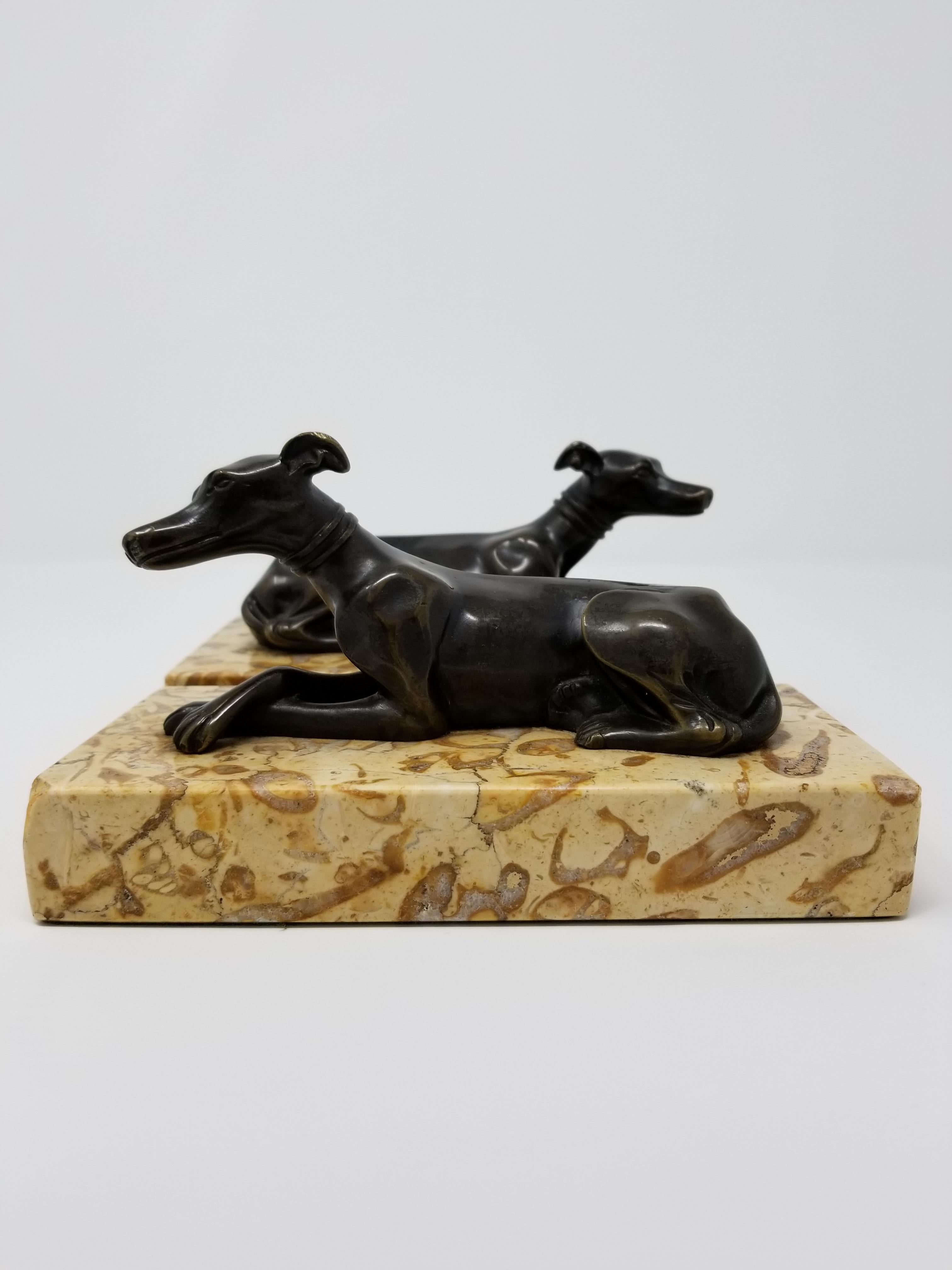 A Beautiful Pair of 19th Century Antique Grand Tour Patinated Bronze Grey Hounds Seated on Marble Plinths. Each dog is beautifully cast and hand-chiseled with meticulous craftsmanship. Each dog is further decorated in a beautiful brown patina, with