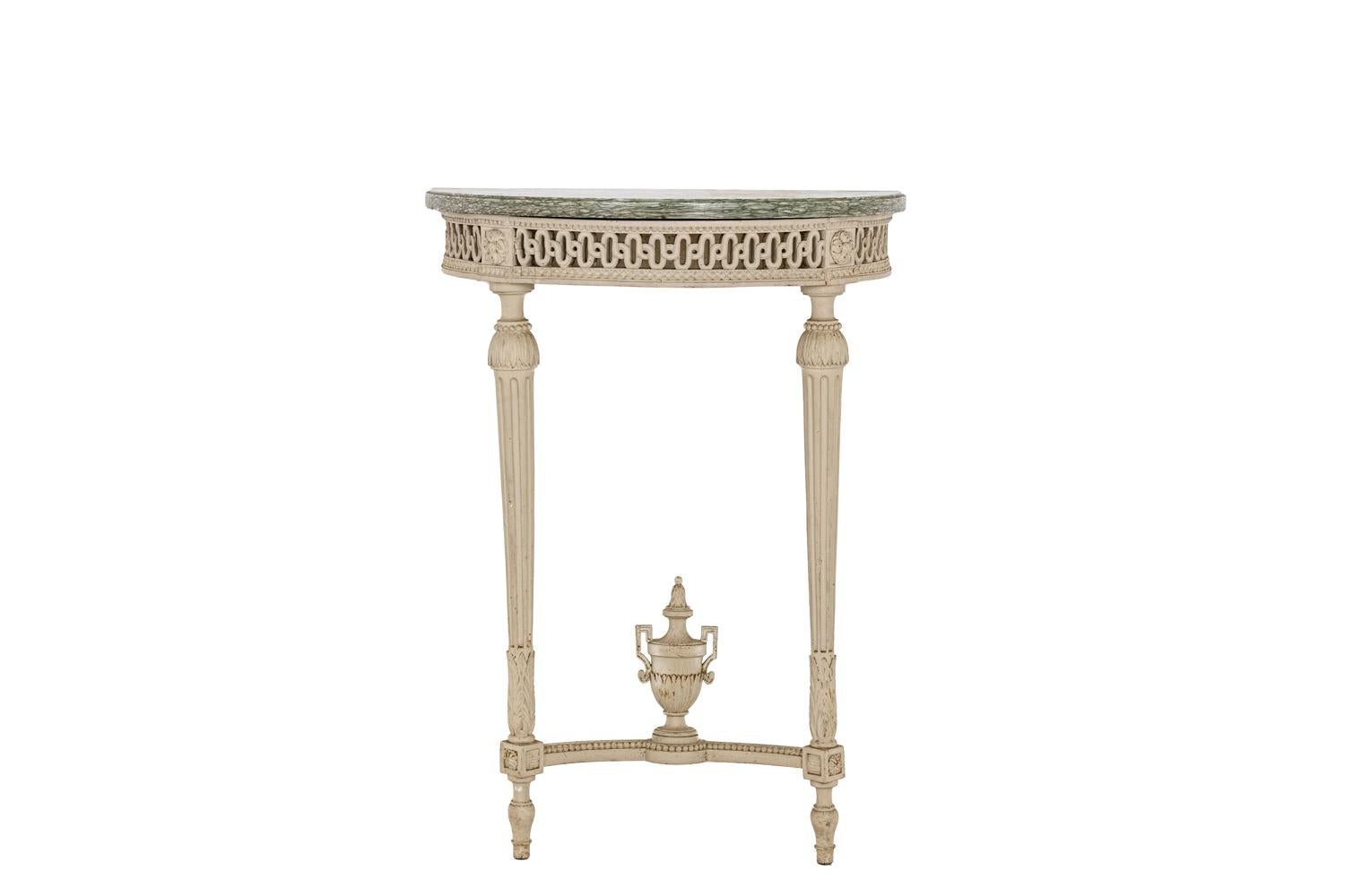 Half-moon console in gray lacquered wood - lacquered and carved crosspieces with an openwork interlacing pattern - pearl friezes - fluted and tapered feet joined by a spacer decorated with a fire pot - spinning top feet - rosettes in the connection