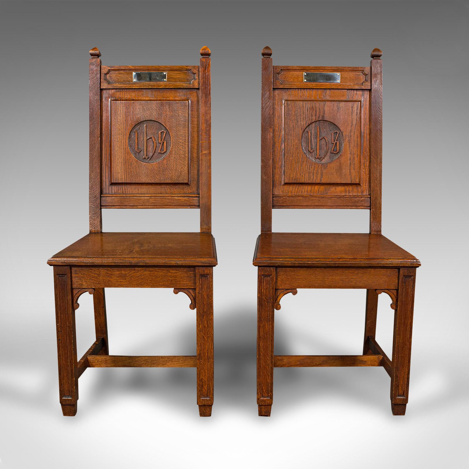 This is a pair of antique hall chairs. An English, oak, occasional dining seat displaying ecclesiastical taste, dating to the late Victorian period, circa 1900.

Robust and impressively stout chairs with beautiful figuring.
Displaying a desirable