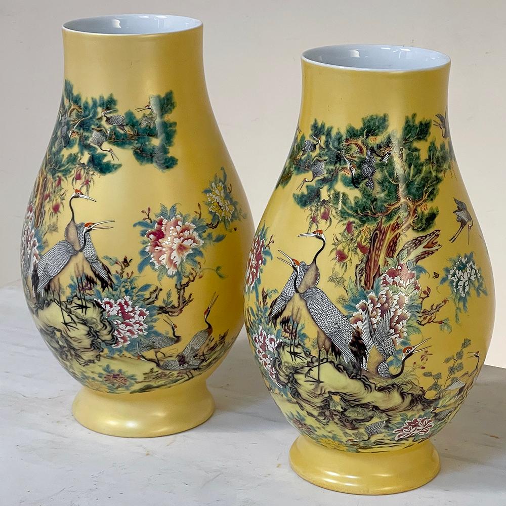 Pair Antique Hand-Painted Chinese Vases exhibit an unusual color combination with a wide palette of earth and jewel tones represented, and display incredibly artistic scenes with exotic birds, flowers and a forest setting in vivid coloration