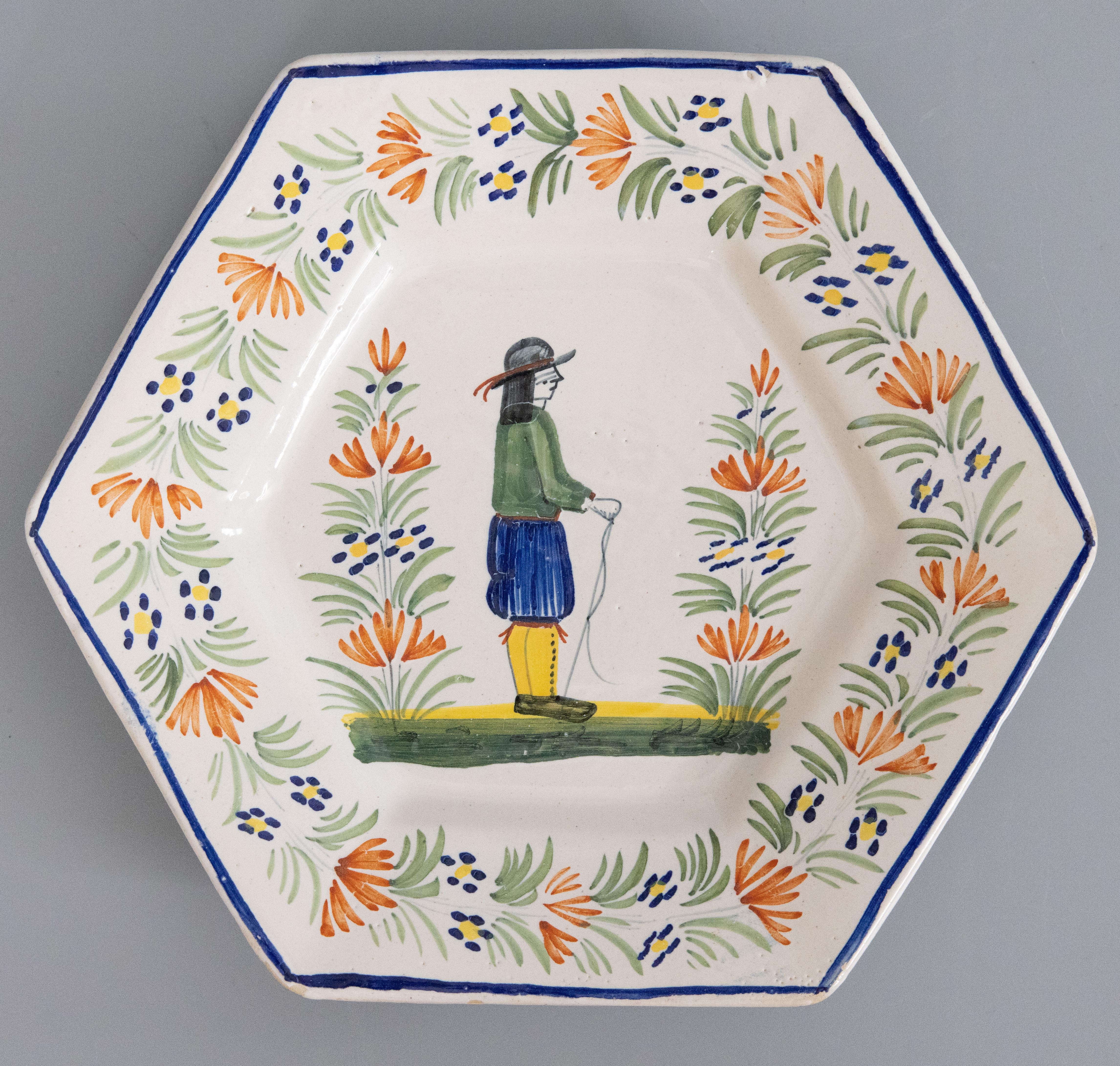A charming pair of antique French faience Quimper plates in a rare hexagonal shape, circa 1900. Unmarked. These collectible hand painted plates feature the classic Breton man and woman in vibrant colors. They would look lovely displayed on a shelf