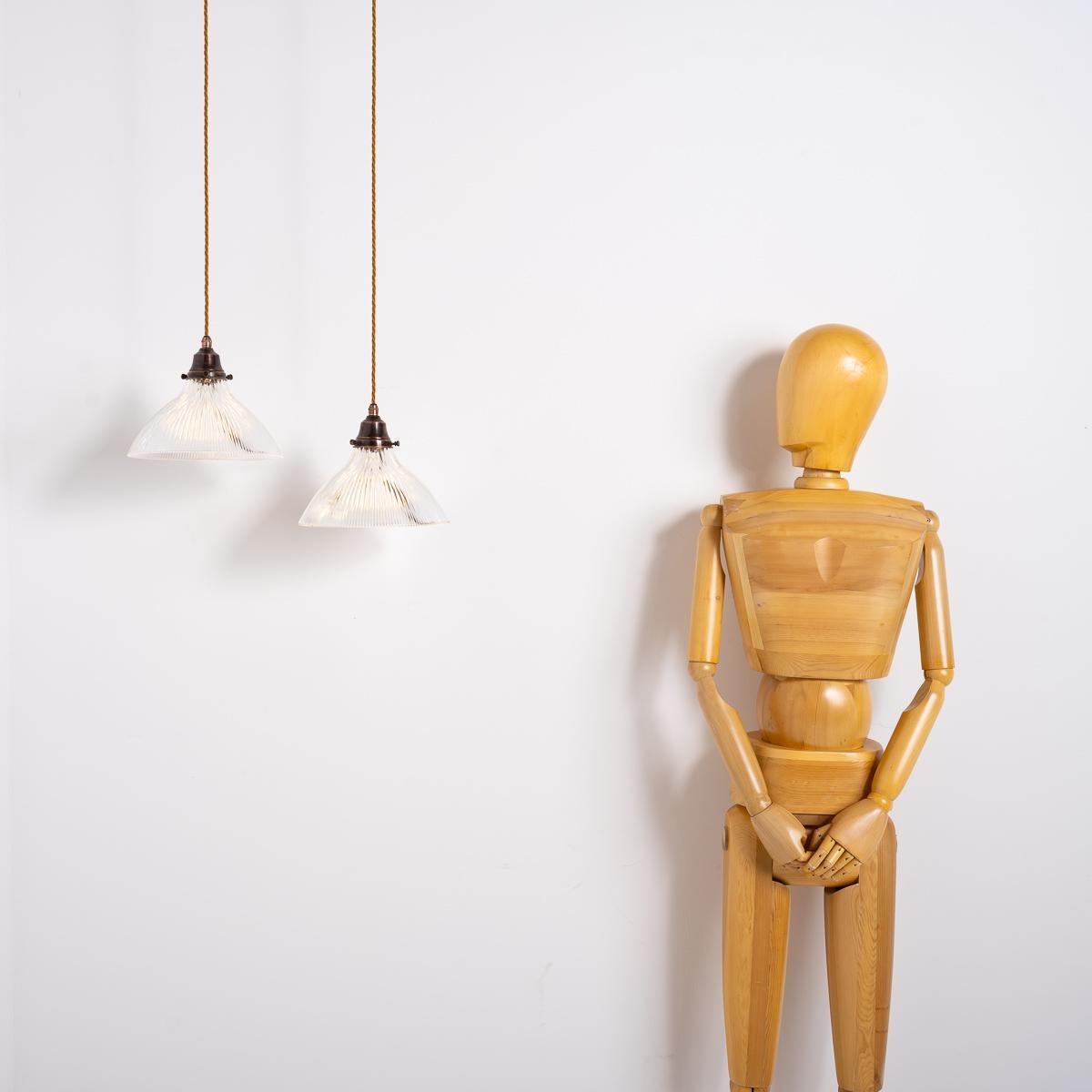 Holophane Elegance: Pair of Antique Fluted Glass Pendants

Elevate any space with this pair of antique Holophane pendant lights. Each large glass shade features a distinctive fluted design, engineered to maximize the diffusion of light, the glass is
