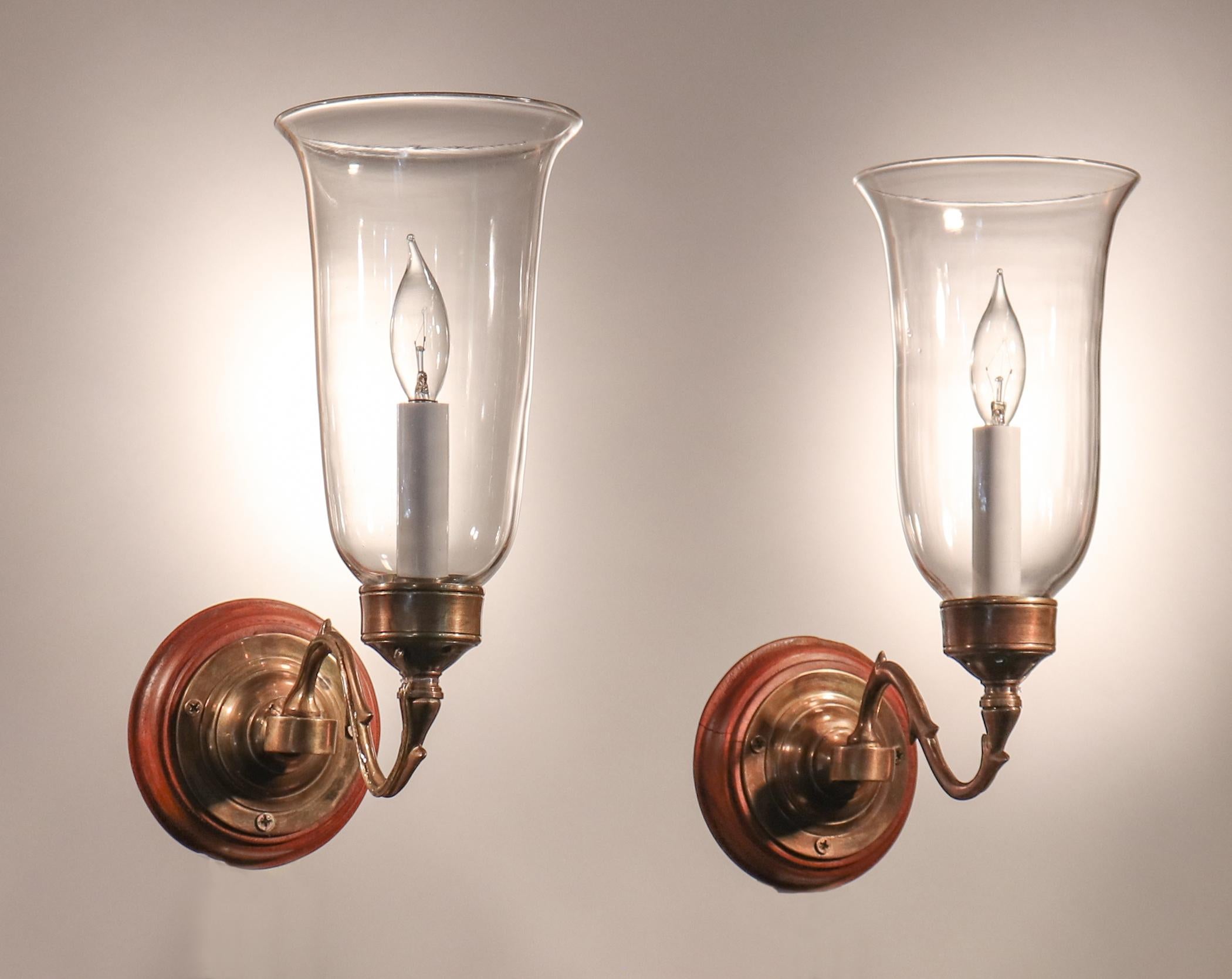 A diminutive pair of antique English hand blown glass hurricane sconce shades with lovely form and a gentle flair. These circa 1900 shades have been newly electrified, each with a single candelabra bulb, and arrive ready to install using the