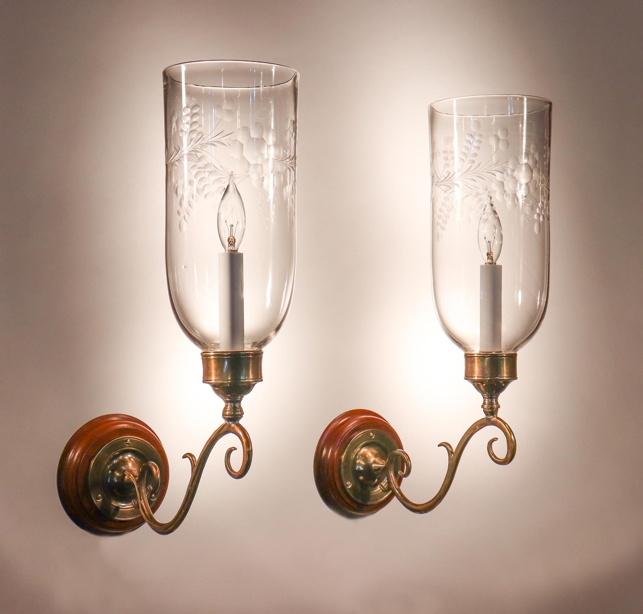 An exquisite pair of English hurricane shade wall sconces with etched floral motif. These circa 1880 shades feature an attractive, straight form and desirable swirling in the hand blown glass. The sconces have been newly electrified, each with a