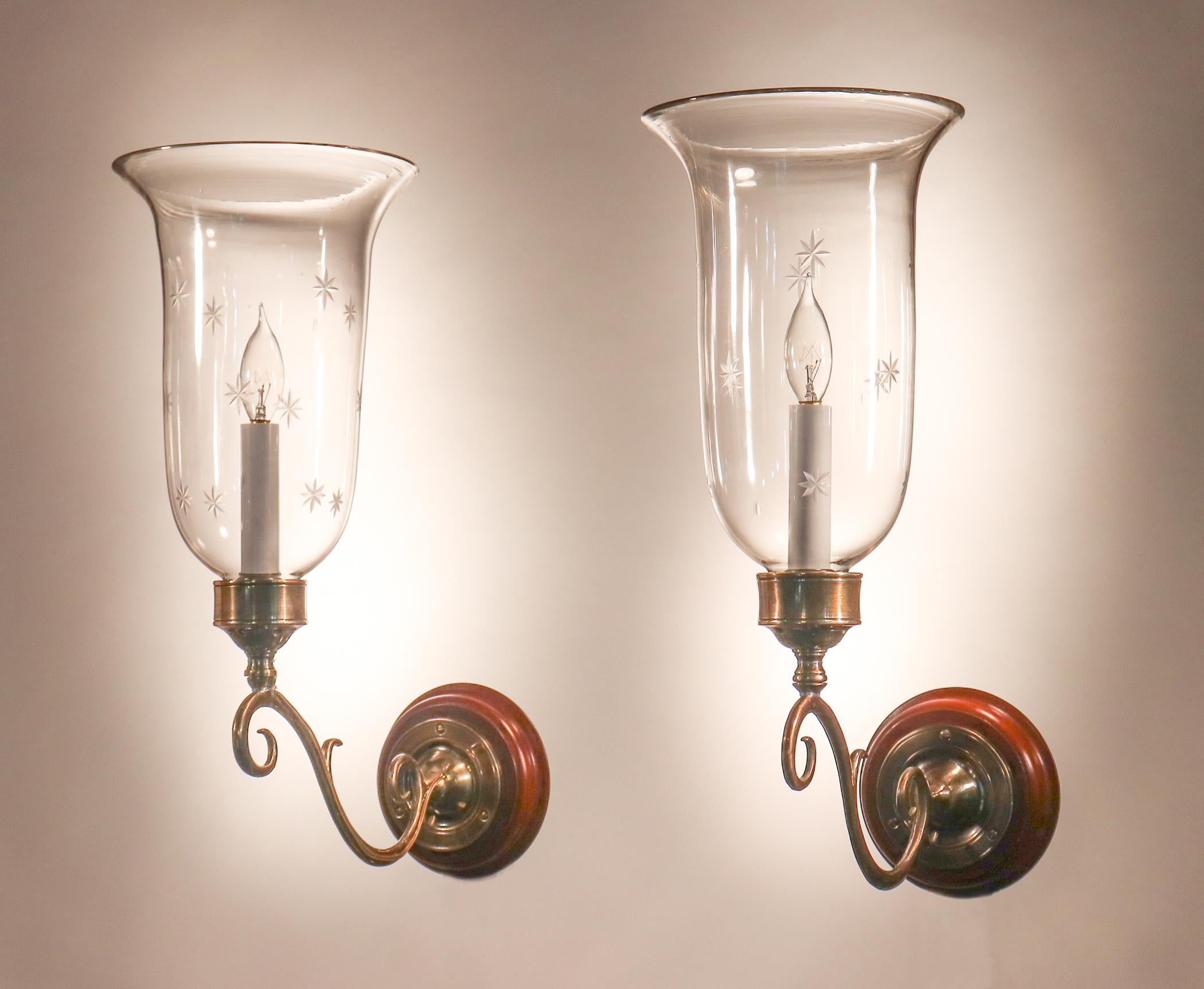 A lovely pair of flared hurricane shade wall sconces from England, circa 1900. These graceful shades have a finely etched star motif, as well as desirable air bubbles in the hand blown glass that speak to the quality and age of the shades. The