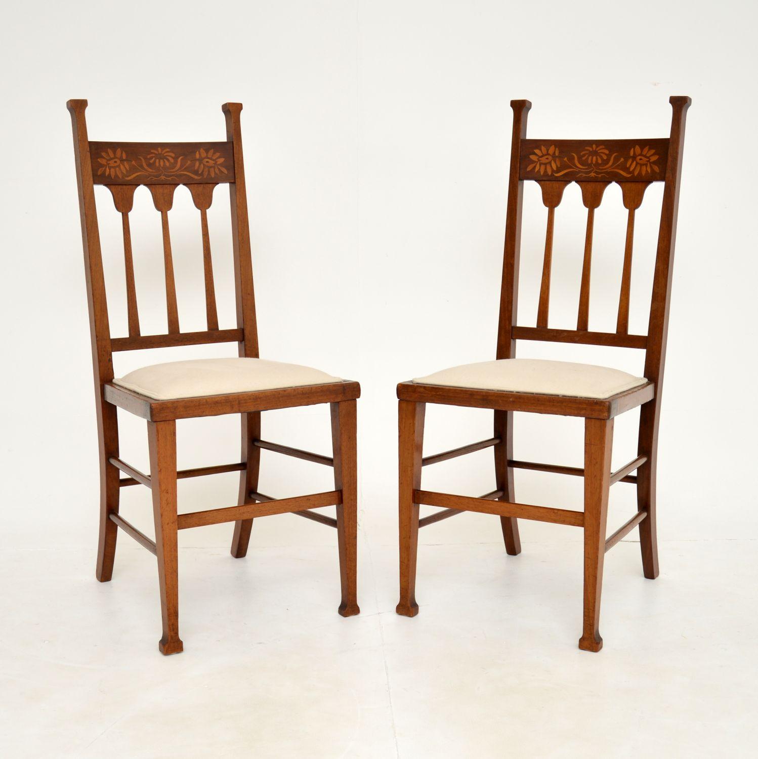A gorgeous & stylish pair of antique Arts & Crafts period side chairs in solid wood. These were made in England, they date from around 1890-1900 period.

The quality is excellent, these are beautifully crafted and have stunning floral inlaid