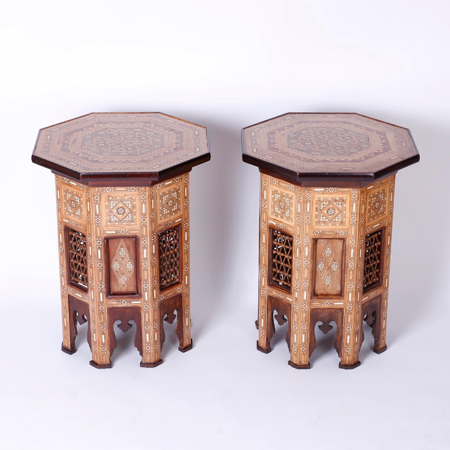 Exotic pair of antique Syrian stands with an octagon form and inlaid walnut, mahogany, king wood, and bone through out. The top has a remarkable geometric marquetry medallion over a base with stick and ball panels and moorish arched legs.