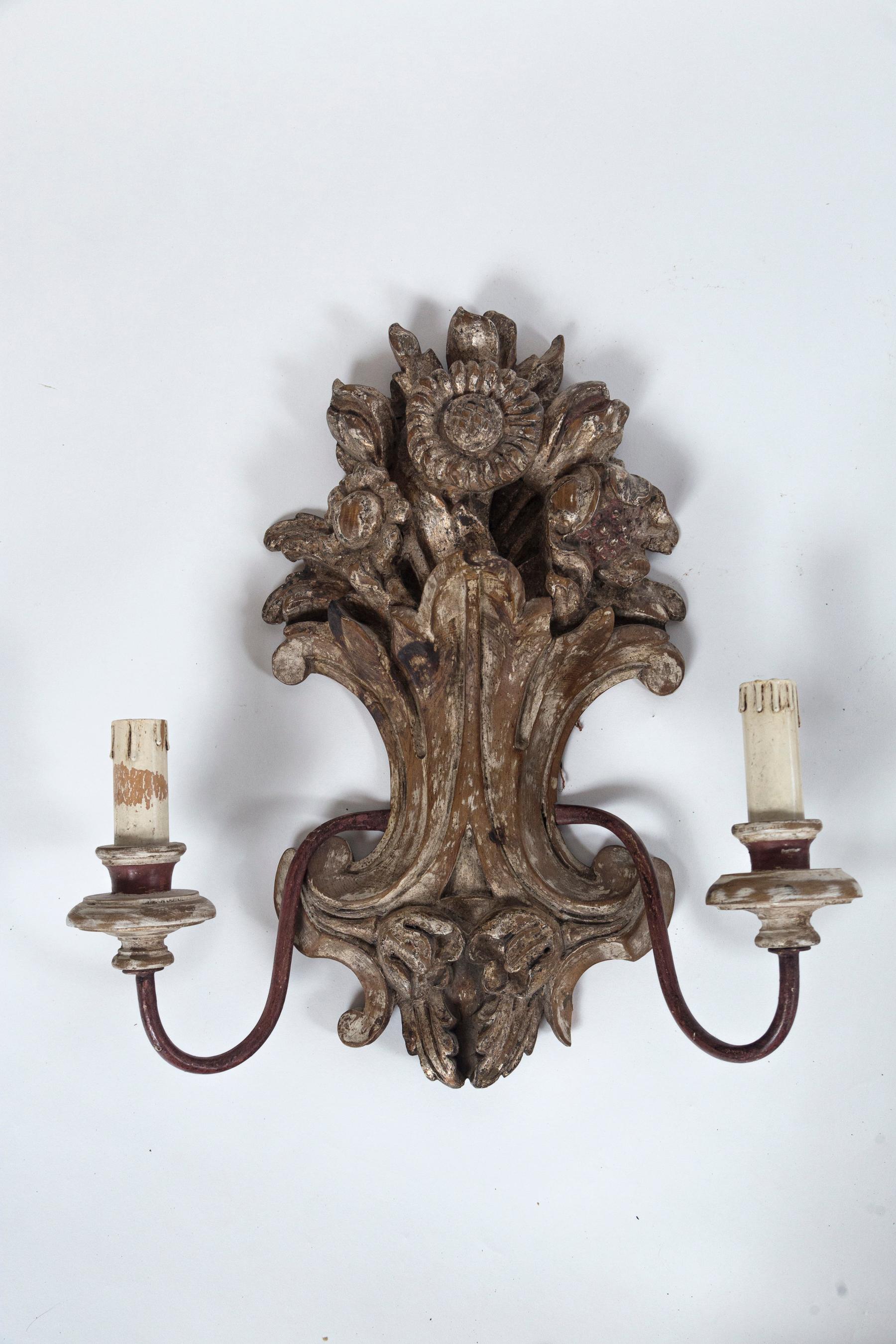 Pair of antique Italian carved wood sconces, early 20th century. Hand-carved floral motif, 2-light sconces. Lovely worn paint finish.