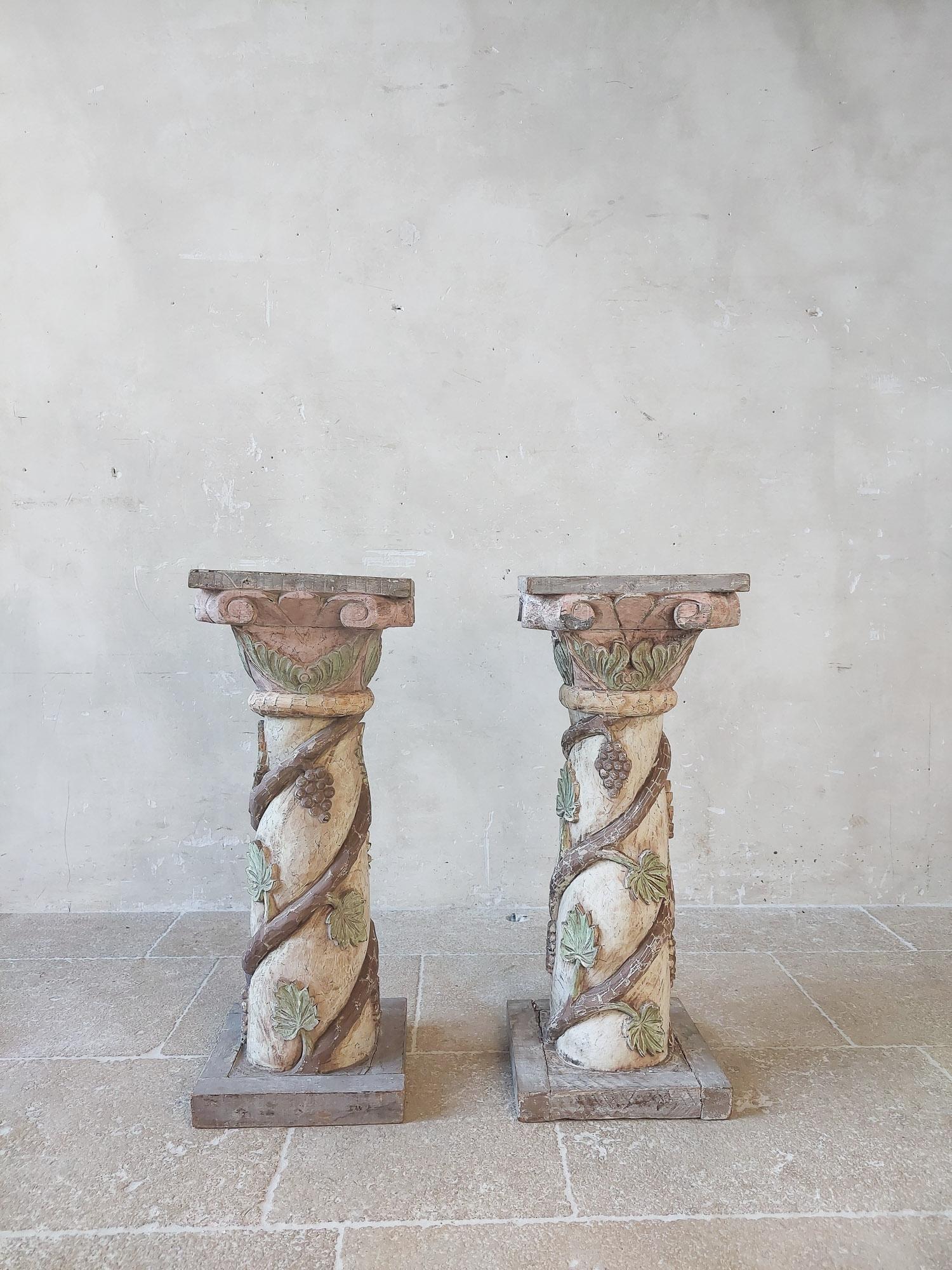 Pair of antique carved wooden pedestals.Italian column parts made into plinths. Beautifully carved wooden details with grape vines. Old patina in soft color tones such as cream, pink, green and grey.

H 76 x 30 x 30 cm.