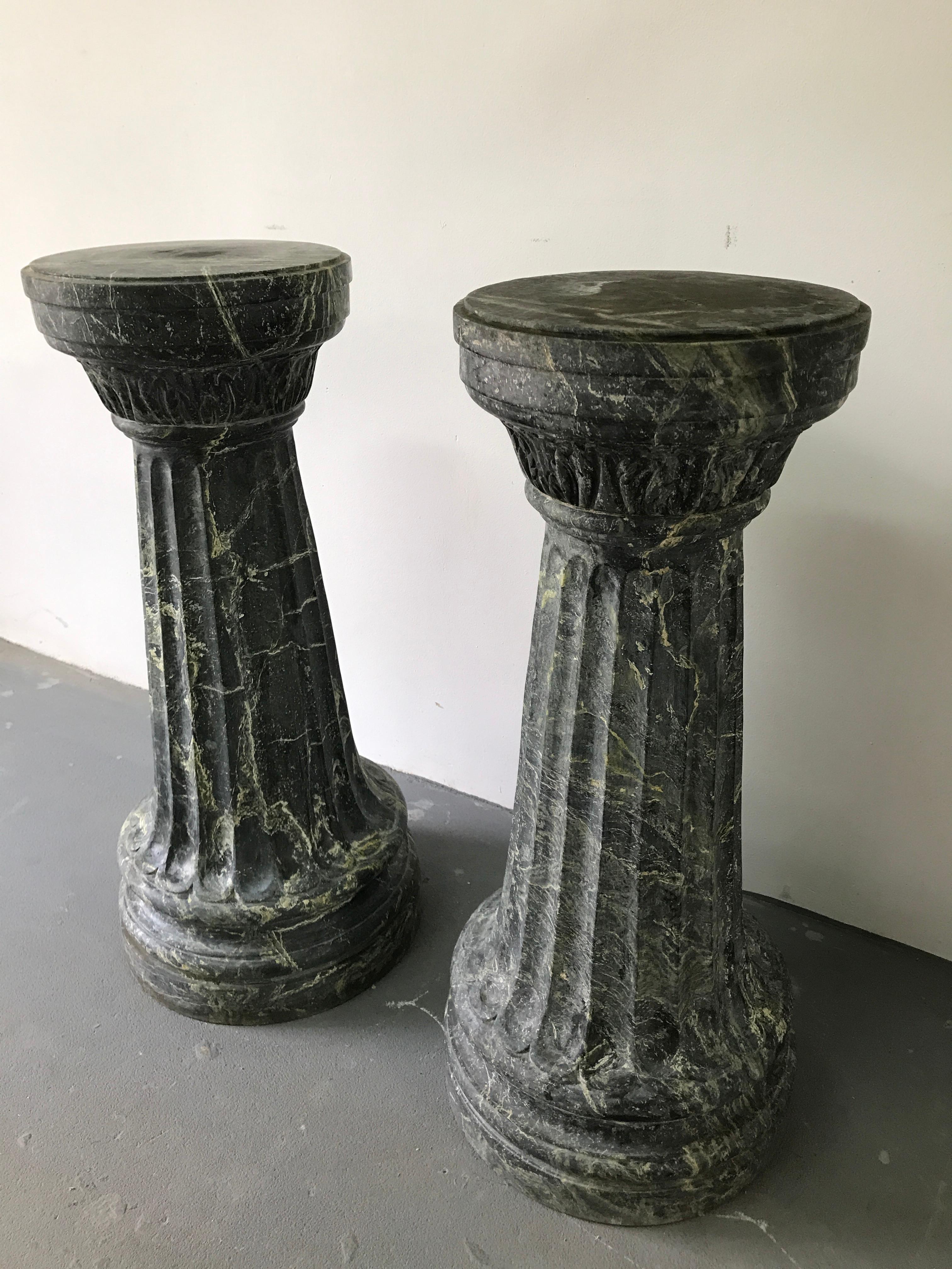 This is a pair of marble columns in green and grey color. These columns have beautiful vertical cutters that give them lightness. The columns are narrowing towards the top.
   