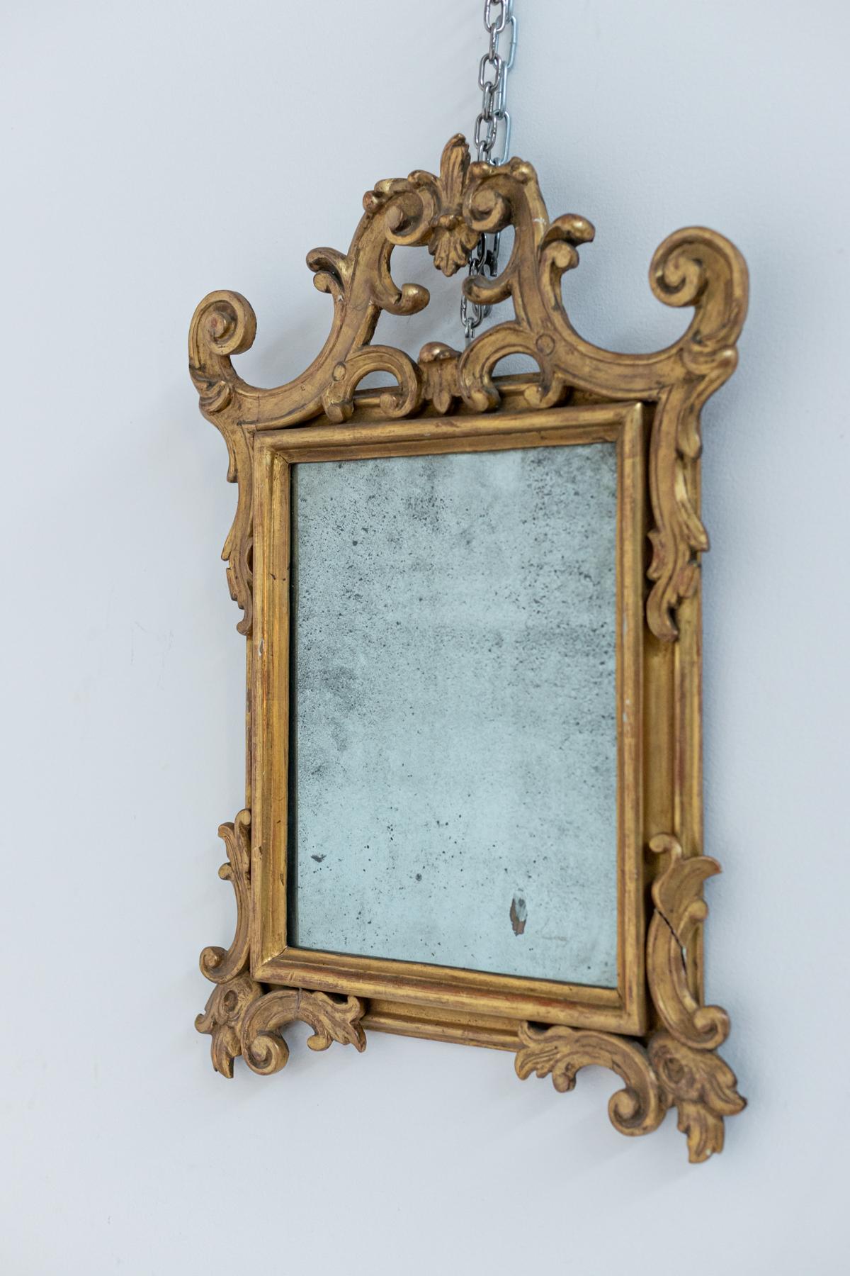 Elegant pair of antique Italian mirrors dating from around 1700. The pair of mirrors is made of carved gilded wood. Its manufacture presents a valuable work of woodworking, we find carved into the wood several baroque elements such as leaves and