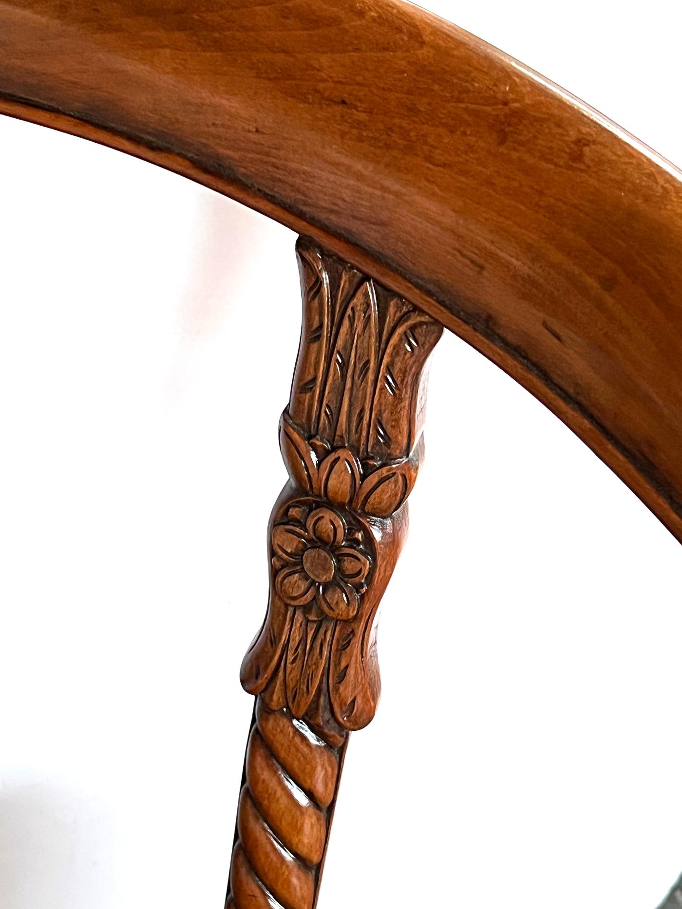 Chacune d'entre elles présente une traverse de crête inclinée et incurvée sur des montants verticaux sculptés en spirale ; elle est reliée à un siège étroit en forme de U au-dessus d'un tablier cannelé, le tout reposant sur des supports cabriole
