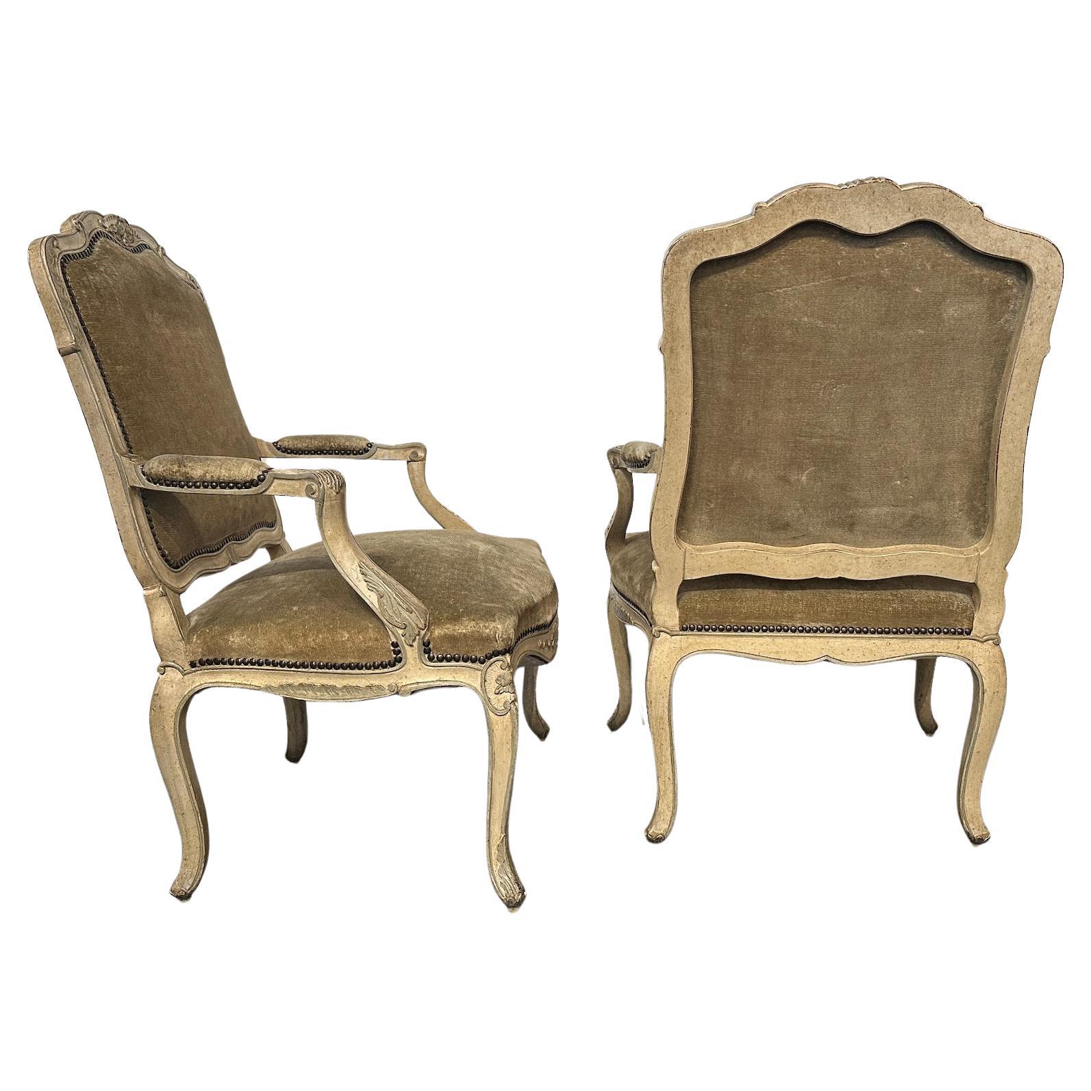 Pareja de sillones tallados y pintados a mano.  Tejido de terciopelo vintage, ribeteado con cabezas de clavos. 