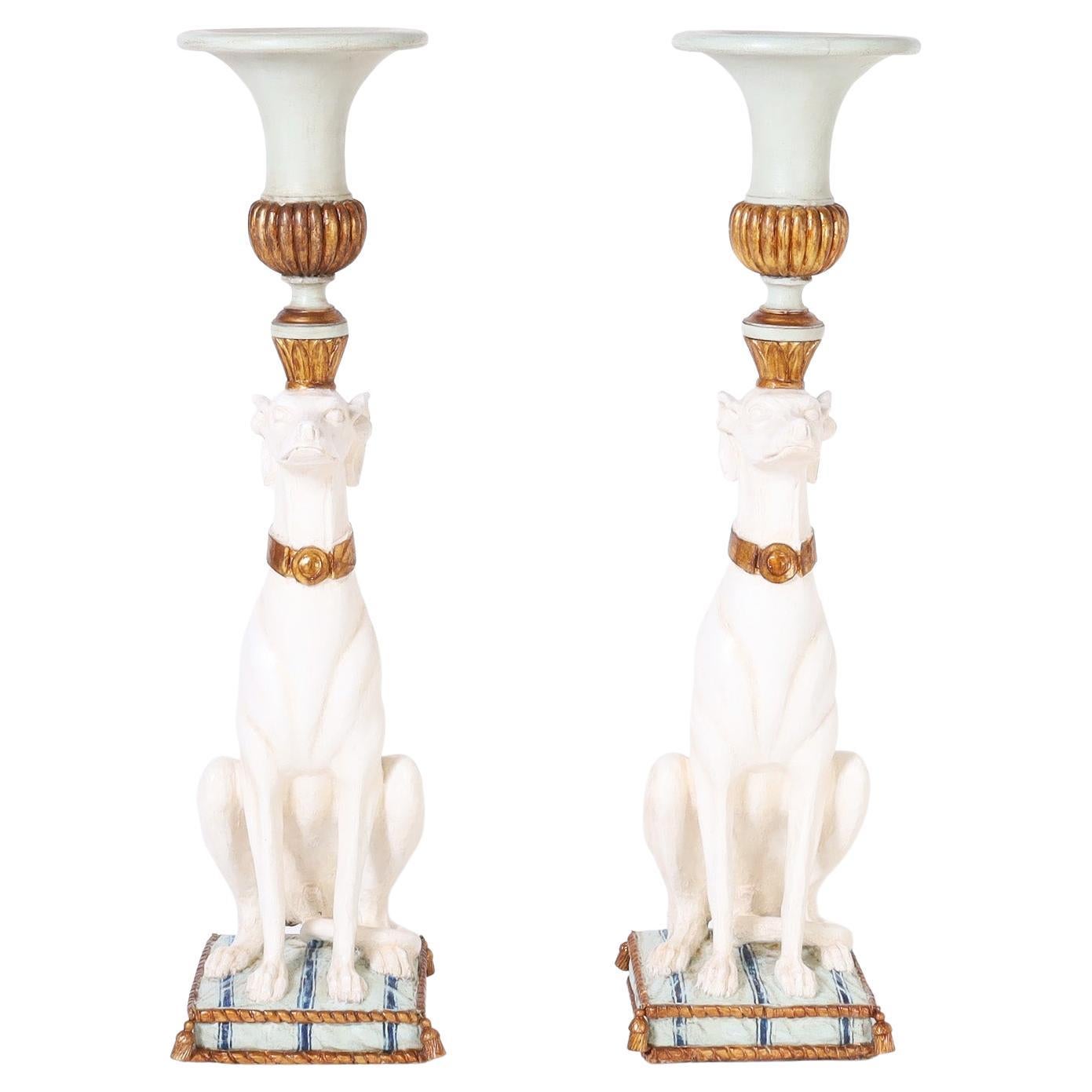 Handsome pair of antique Italian whippets or dogs carved from hardwood paint decorated and parcel gilt depicting the pair seated on pillows while balancing urns on their heads.