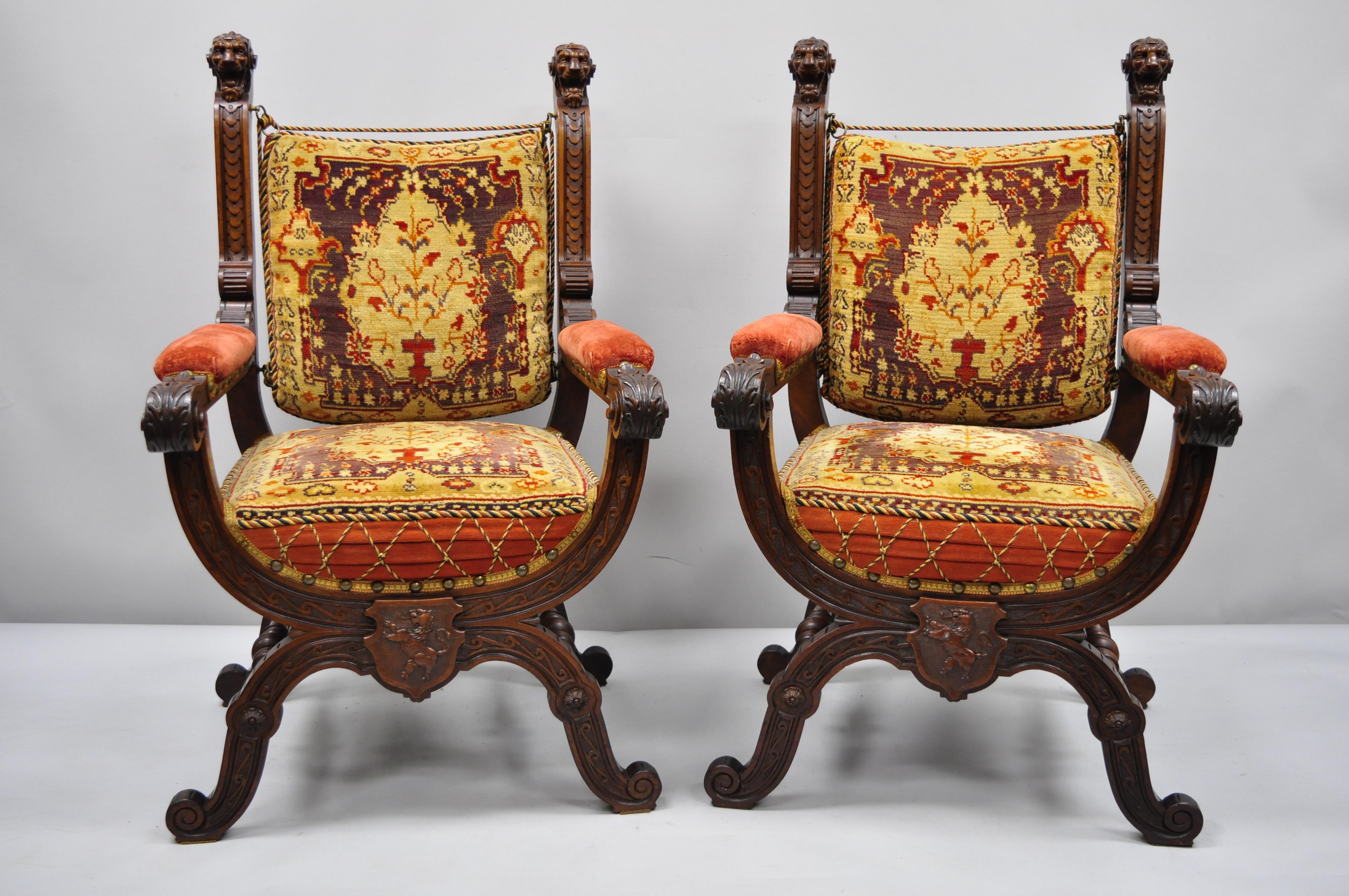 Pair of antique Italian Renaissance Savonarola throne armchairs with lion heads. Item remarkable lion head finials, roaring lion lower carved medallion, stunning pillow upholstery which appears to be a thick carpet like wool fabric, solid wood