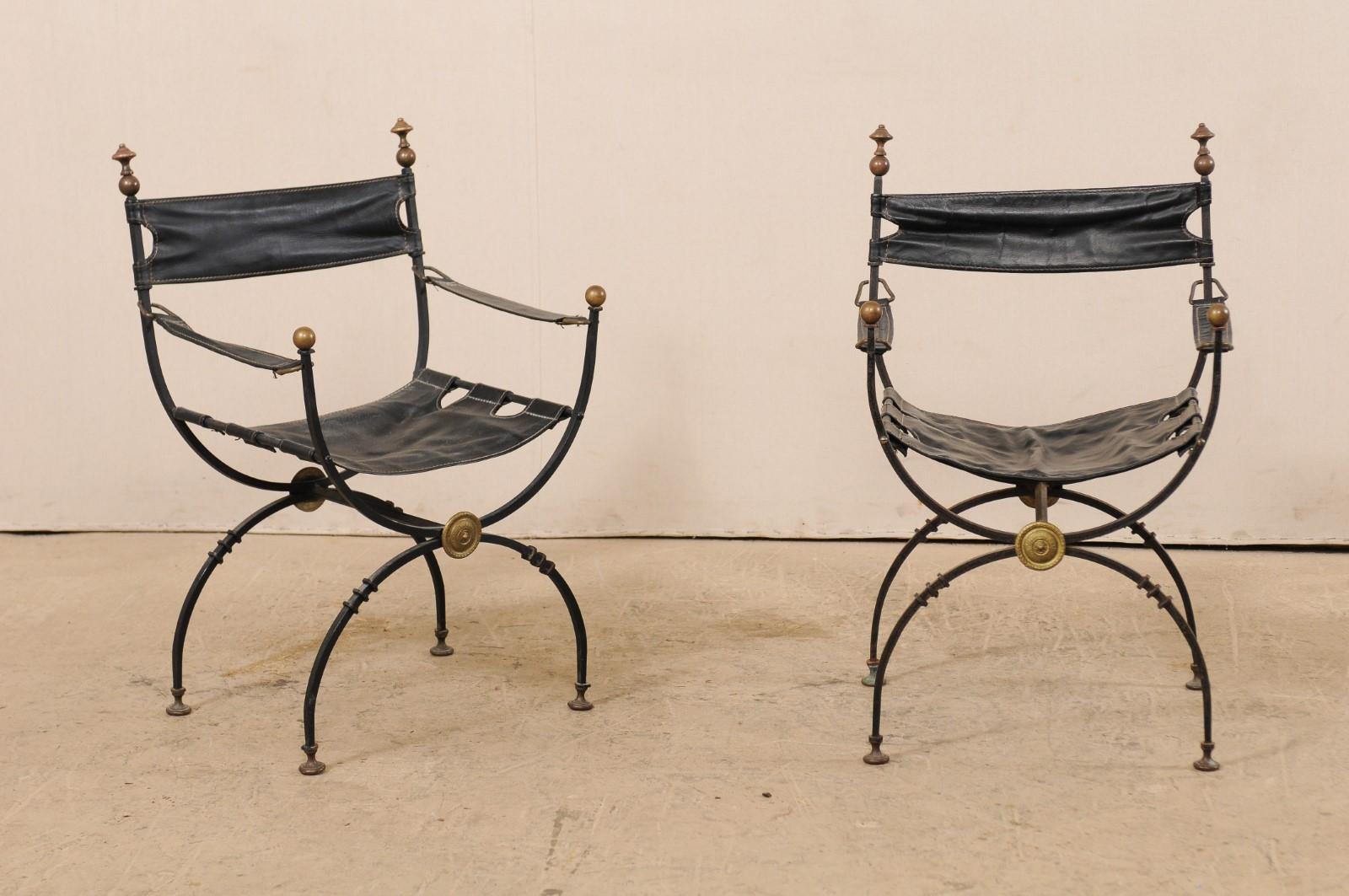 A pair of Italian curule savonarola chairs with black leather from the early 20th century. This pair of antique Italian curule chairs, also commonly called savonarola, which are defined by their signature semi-circular frames which connect where the