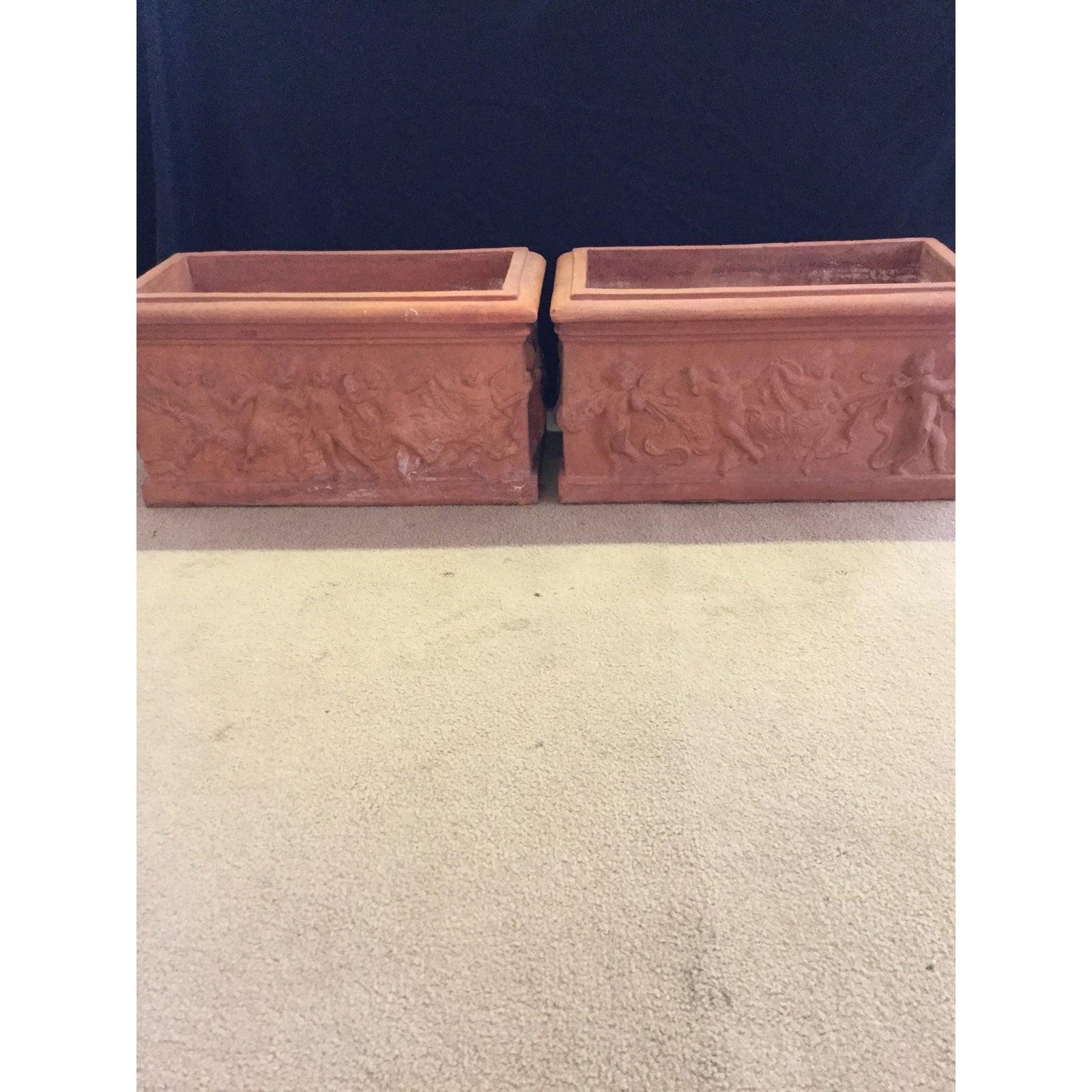 Beautiful pair of antique Italian terracotta garden planters with cherubs. All four sides of this pair of garden planters have different motifs and date to the 1920s. This lovely pair of antique Italian terracotta planters have dimensions as