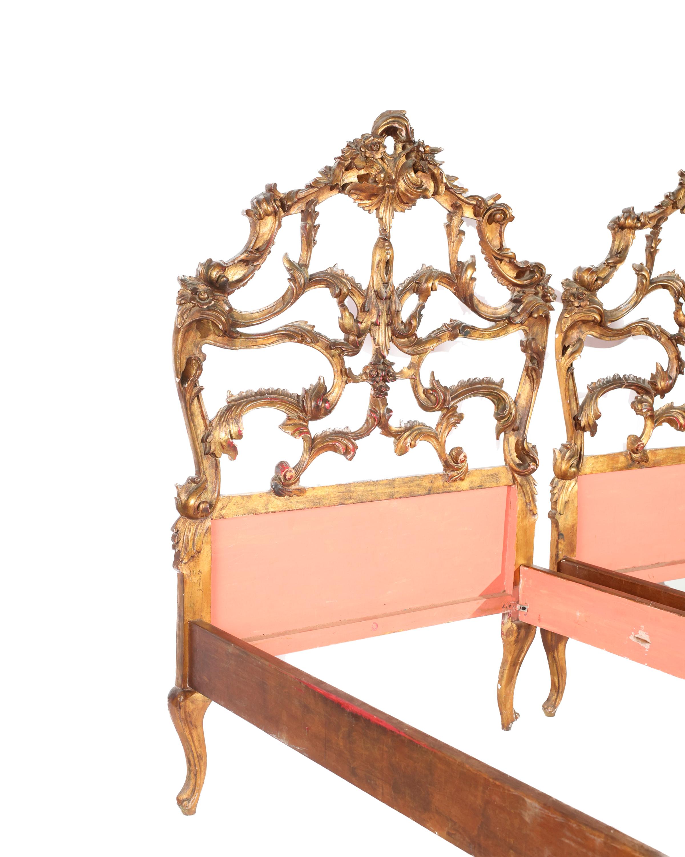 An extraordinary pair of ornately carved Italian giltwood beds purchased in Beziers, France. The pair would be stunning used traditionally as a pair, or together as a King sized bed. The impressive height of the gilt headboards have stunning impact