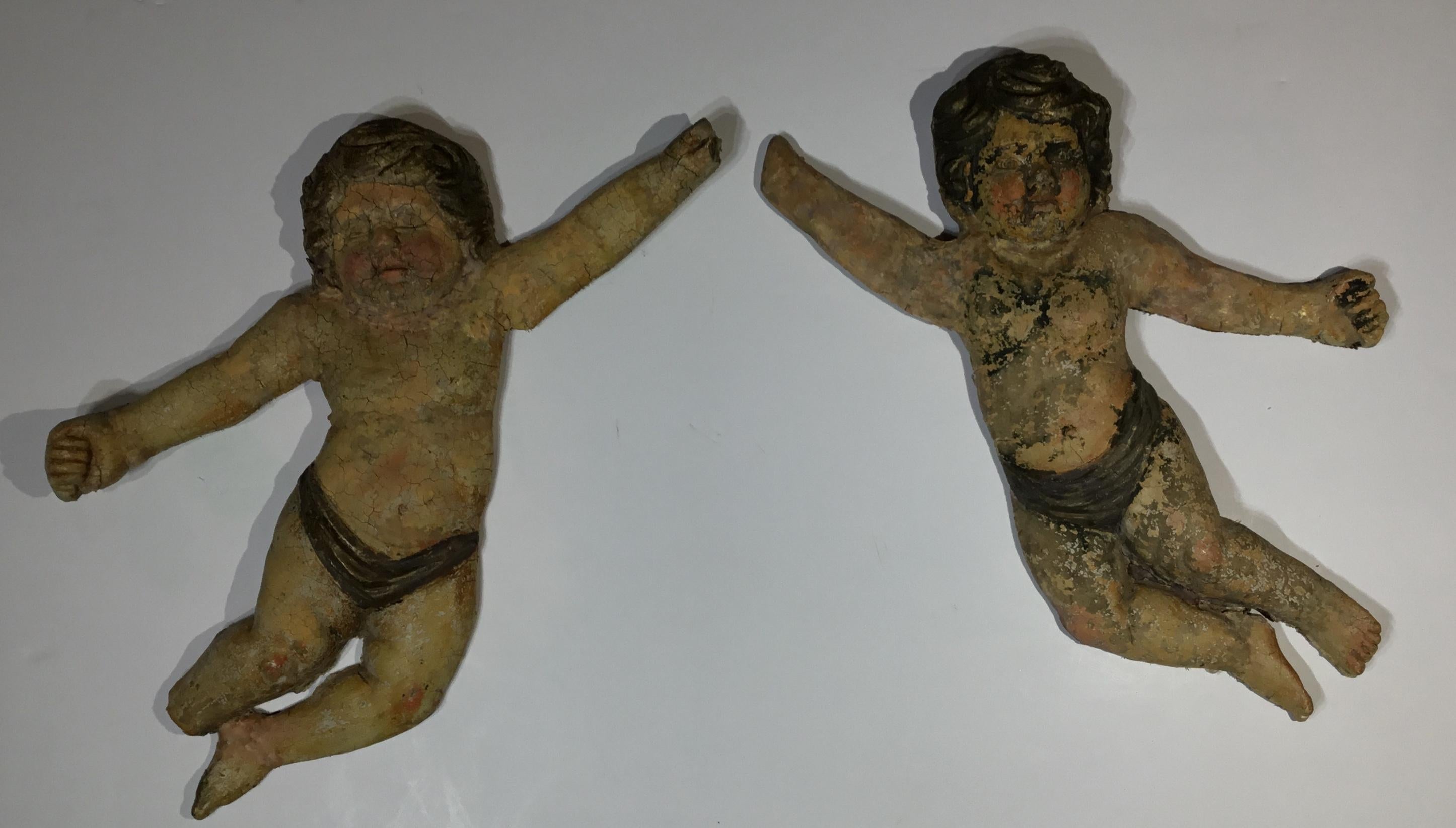 Exceptional pair of antique terra cotta cherub beautifully sculpted by the artist and hand painted. These pair of cherub were salvaged from estate in Italy and professionally restored so they are structurally strong and able to hang on the wall.