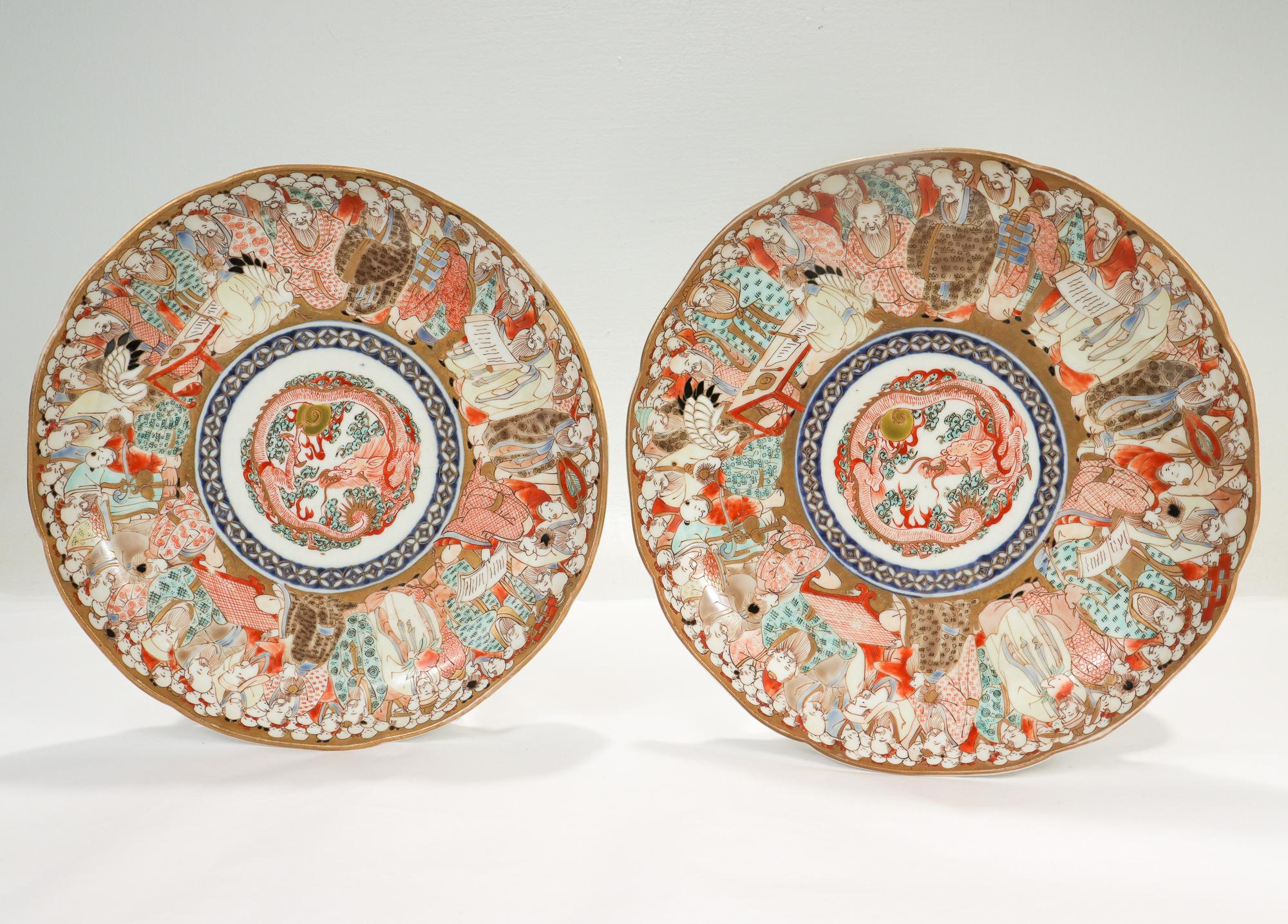 A pair of fine Japanese Imari porcelain plates.

The center of each plate has a depiction of a red Eastern dragon among blue clouds with gilt highlights.

The rims of the plates are decorated extensively with Japanese aristocrats in traditional