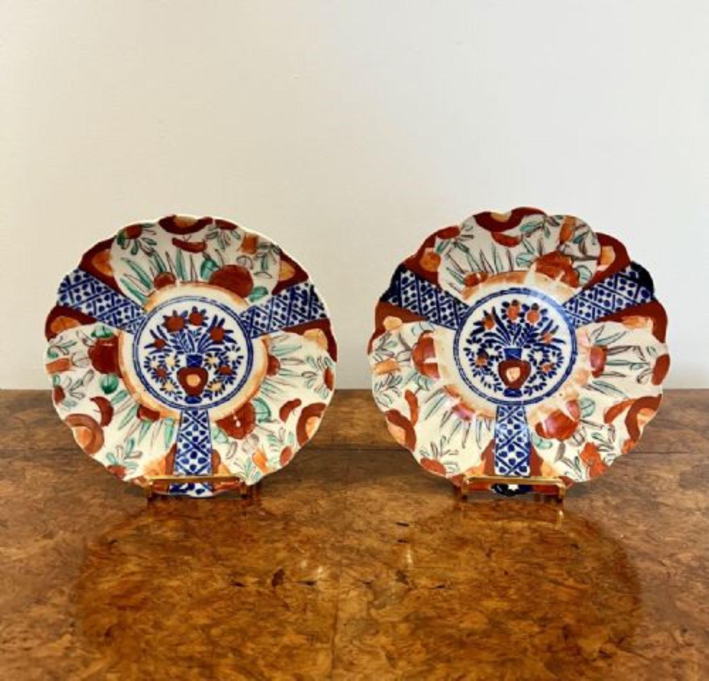 Pair of antique Japanese imari plates having a lovely pair of antique Japanese imari plates with scalloped shaped edges, hand painted with a vase of flowers to the centre surrounded by flowers and leaves in wonderful red, green, blue and white