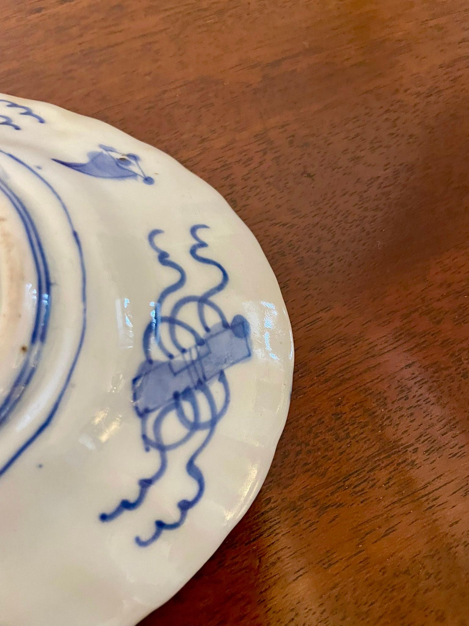 Preciosa pareja de platos antiguos de porcelana japonesa Imari pintados a mano en la tradicional paleta de rojo hierro, azul cobalto y dorado sobre fondo blanco. Cada plato presenta un medallón floral central rodeado de paneles alternados de