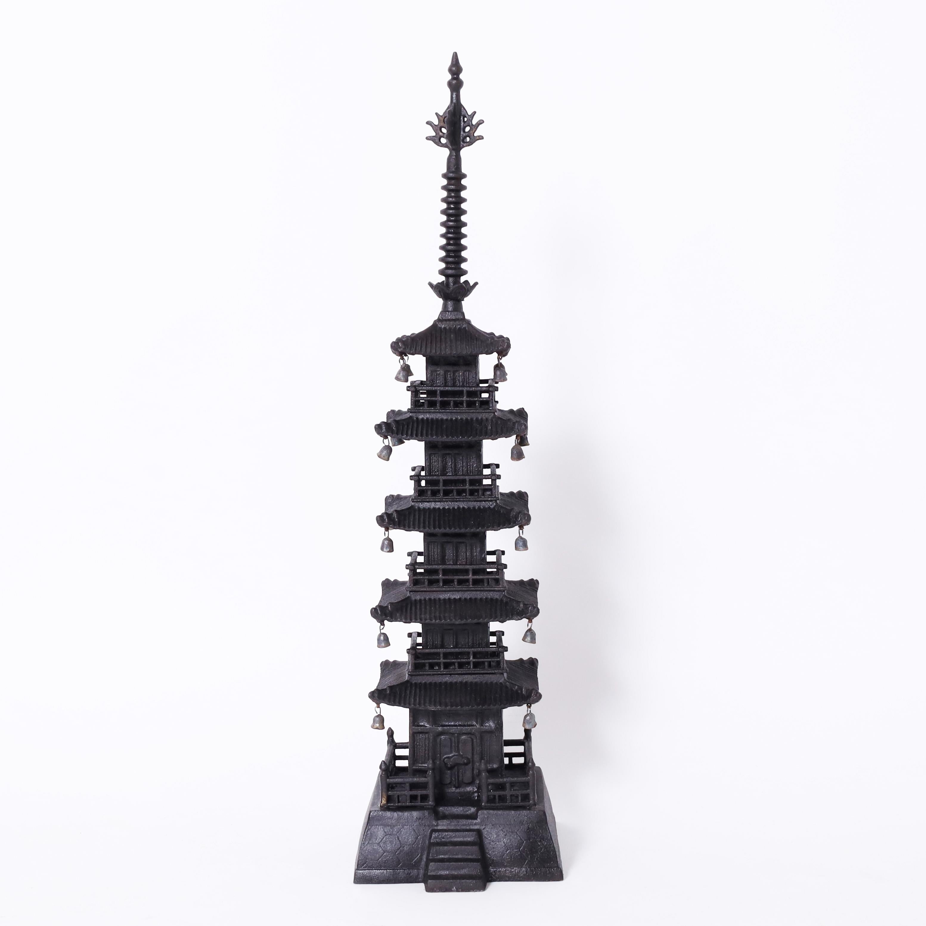 Enchanting pair of Japanese pagodas crafted in iron with classic finials or sorin at the tops on five floors with hanging bells and an entrance at the bottom.