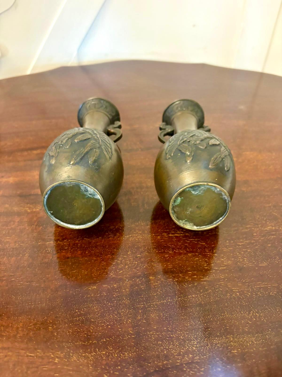 Una squisita coppia di vasi giapponesi in bronzo del periodo Meiji, splendidamente fusi e finemente dettagliati. Ogni vaso presenta un'elegante silhouette a balaustro arricchita da pannelli foliati in rilievo finemente modellati e ornati da manici