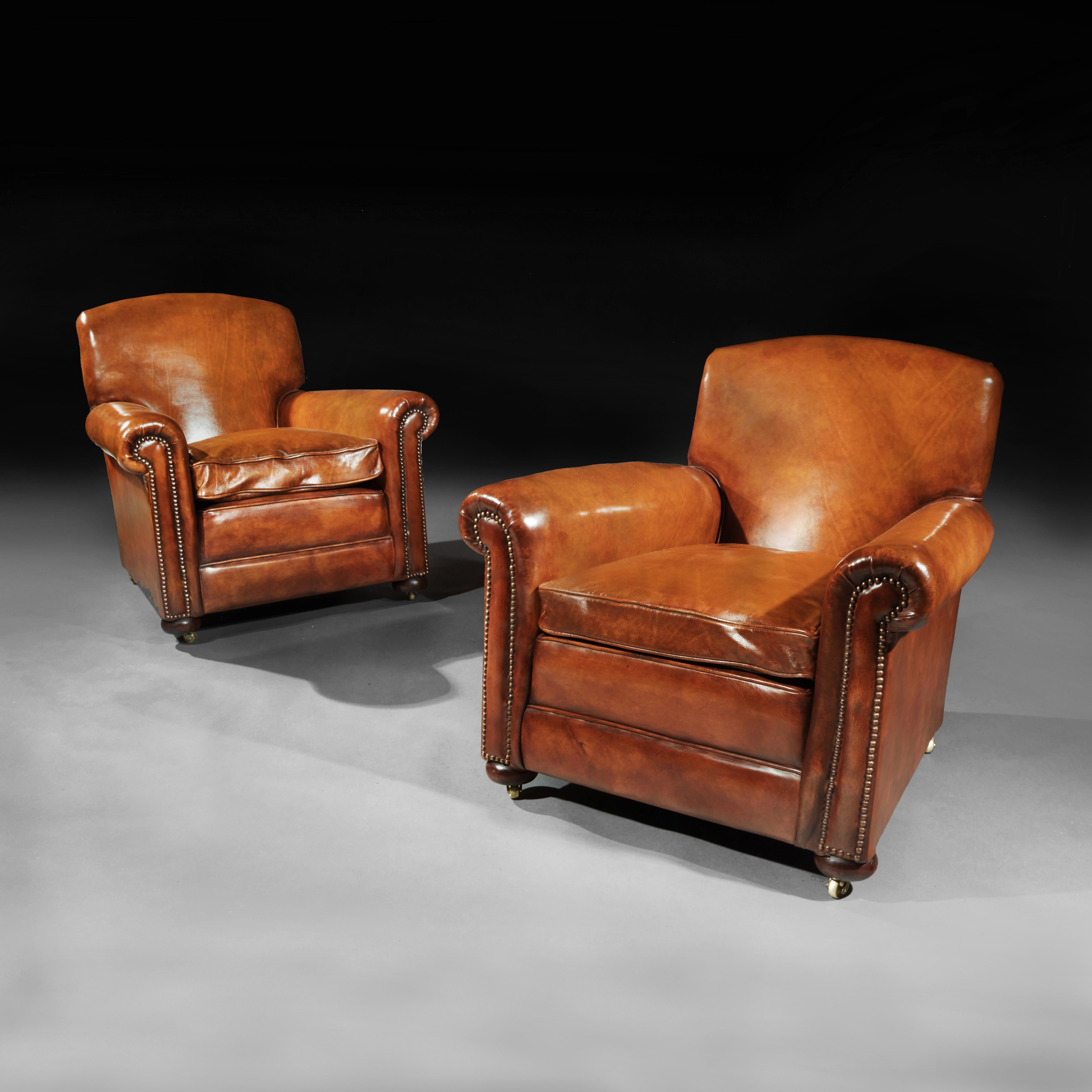 A fine pair of antique leather club chairs raised on turned front bun feet, of very good proportions and extremely comfortable having sprung seat and backs. 

English, circa 1900s

This pair of club chairs date from the early 20th century,