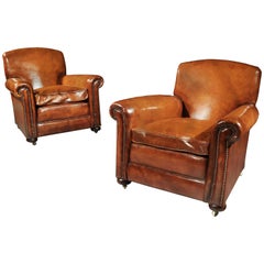 Paire de fauteuils club anciens en cuir