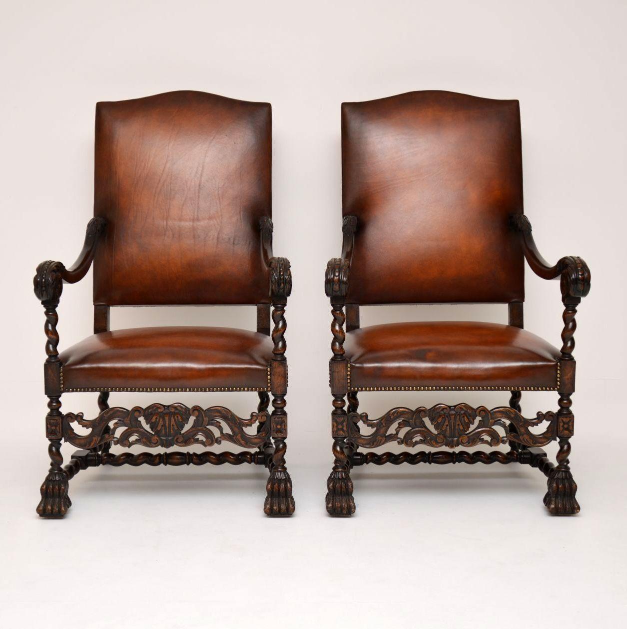 Impressive pair of antique leather upholstered Carolean style armchairs on carved oak frames in excellent condition and dating from the 1890s period. Take an enlarged look at the wonderful carvings, especially below the seats. They have lots of