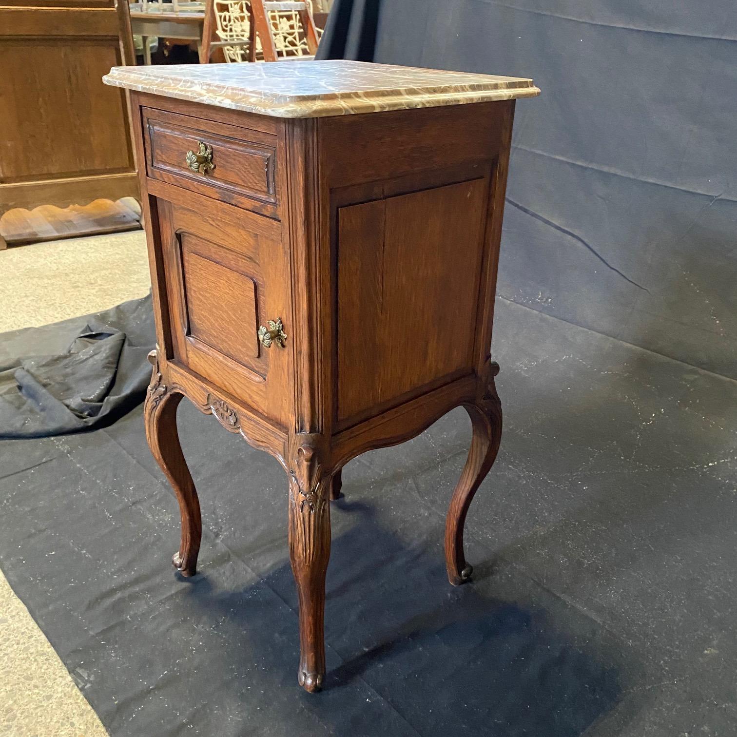 Pair of antique French Louis XV Regency marble top night stands or side tables bought in the South of France. Topped with rich beveled marble, each is finished on all four sides with four scrolled legs ending in escargot or snail feet, making them