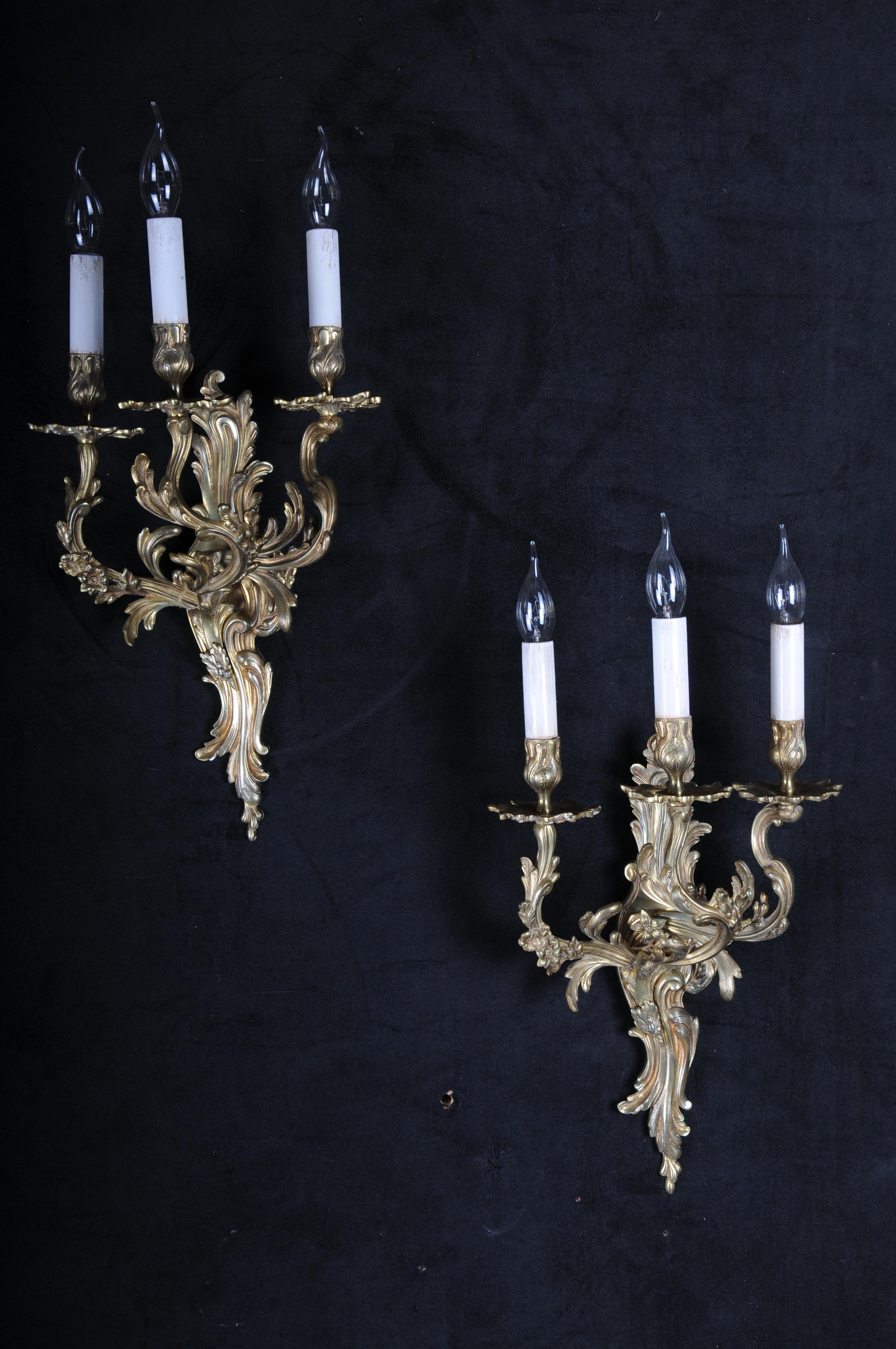 Pair (2) of antique Louis XV wall lamps, bronze

Extremely decorative and magnificent bronze wall lamps, classic shape with curved rocialli arm lamp. Each chandelier has three light bulb sockets. Electrically tested and adjusted to US standards.