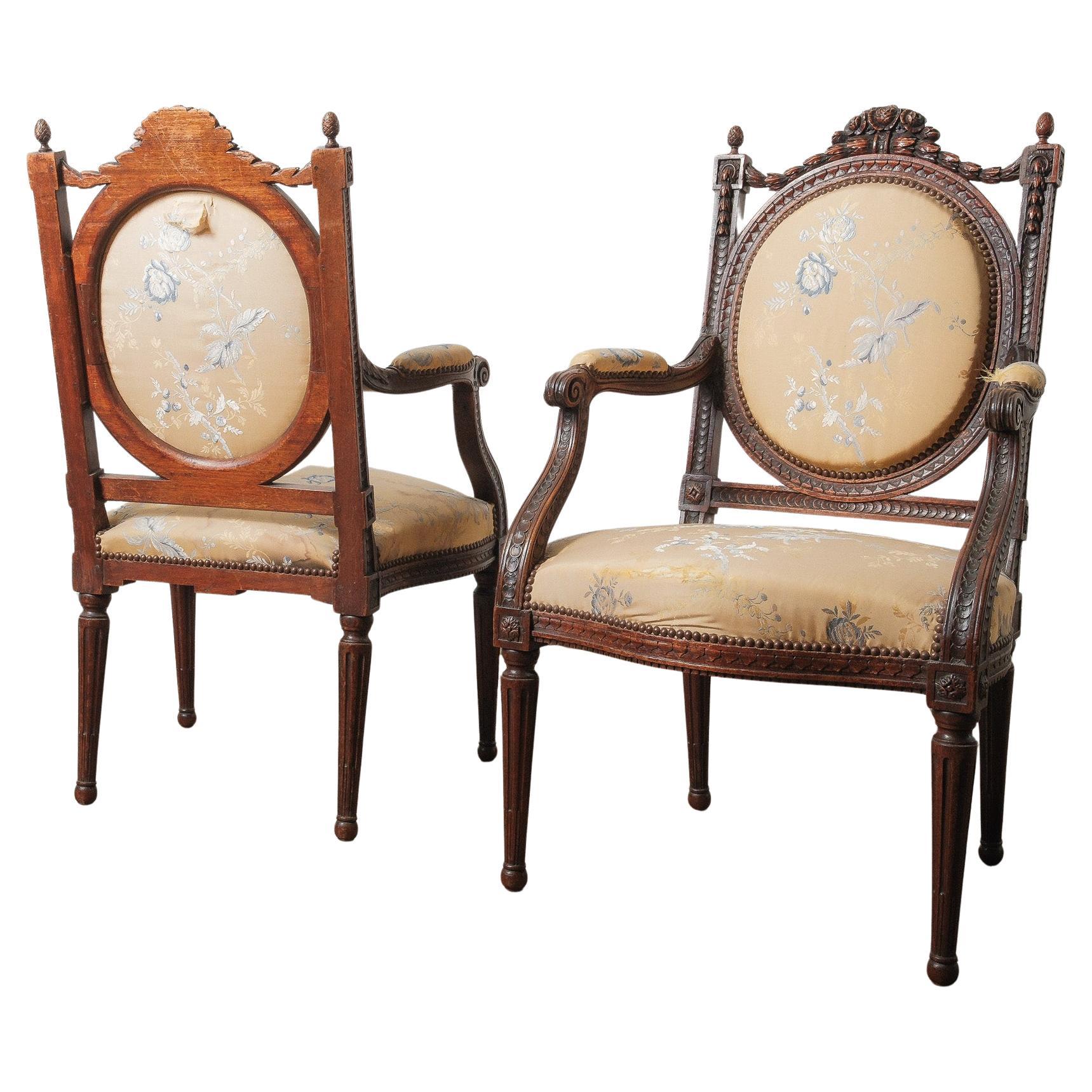 Coppia di antiche poltrone intagliate in stile Luigi XVI con tappezzeria floreale in vendita