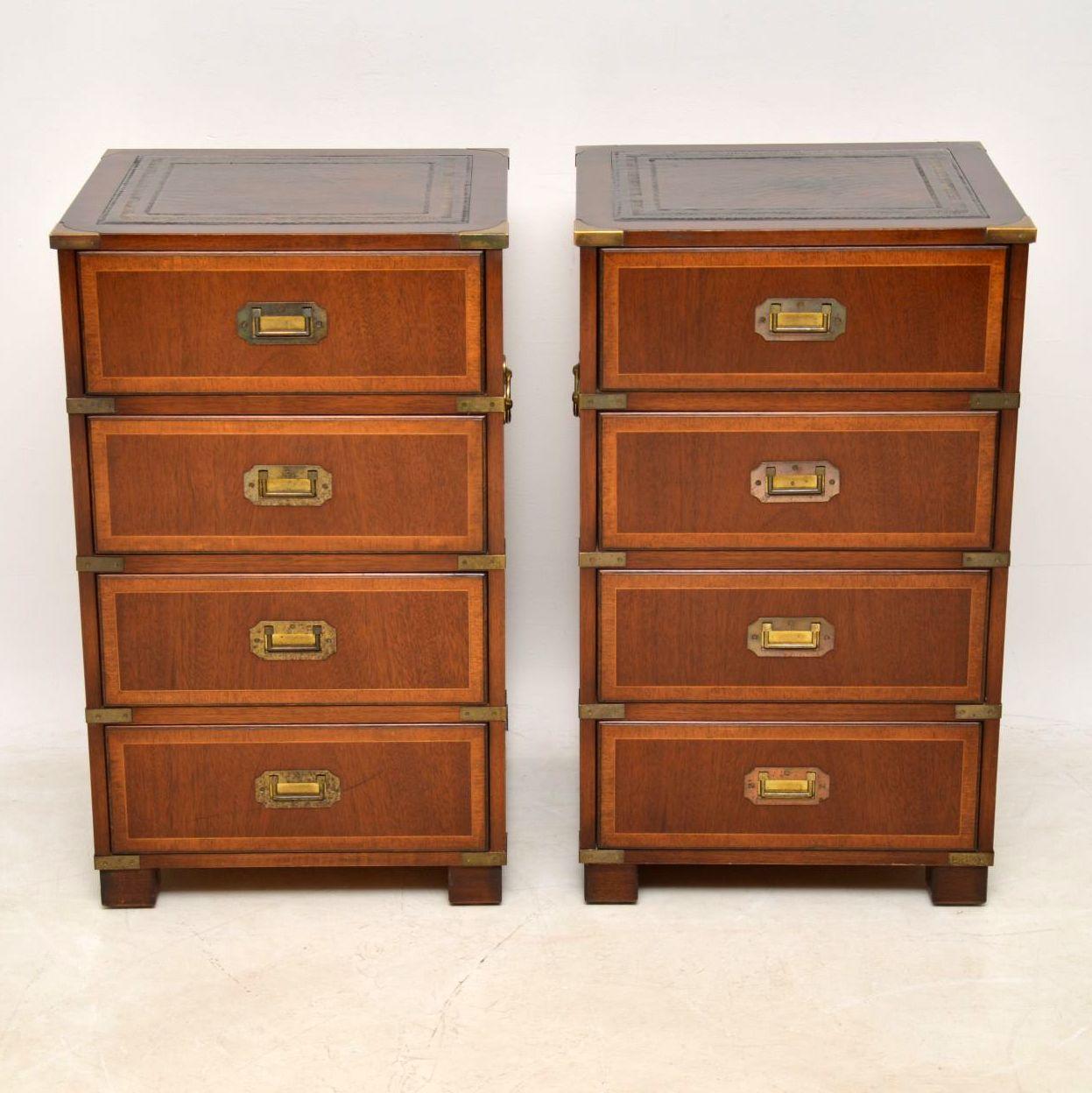 This pair of antique military style bedside chests in mahogany are good quality and have some fine features. They are in good condition, having just been polished and date to around the 1950s period. The tops have tooled leather inserts which have a