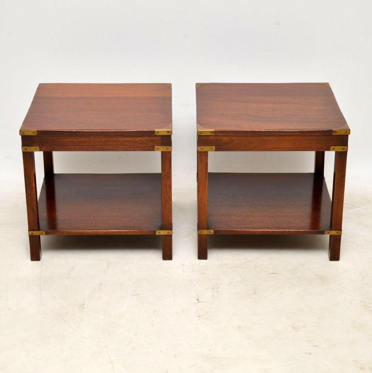 Pair of antique Campaign style mahogany and brass side tables in good condition, dating to circa 1950s period. These types of table are very useful either side of a sofa and great for putting lamps on, plus magazines underneath.

Measures: Width –