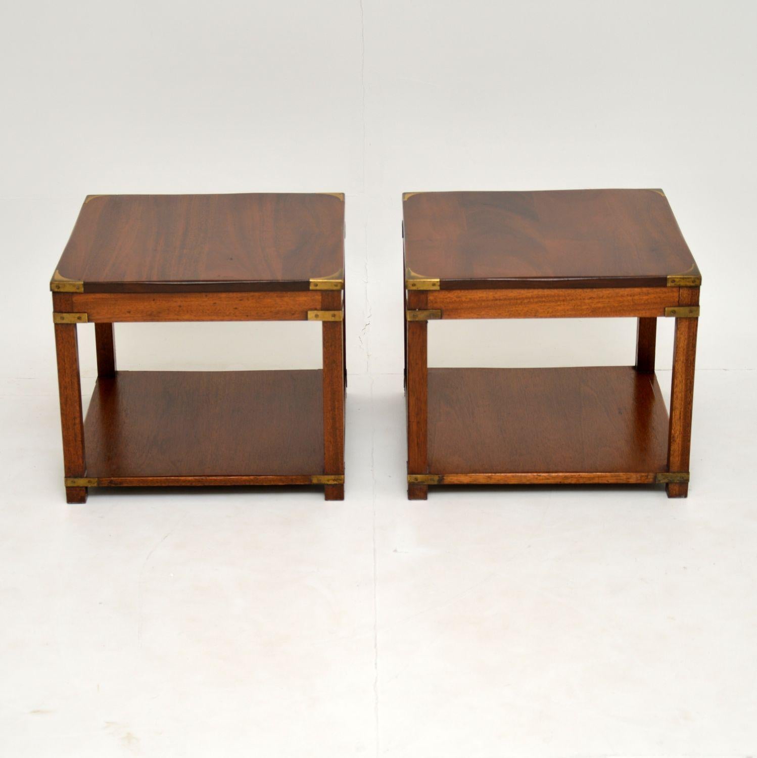 A smart and extremely well made pair of solid mahogany side tables, in the antique military campaign style.

These date from circa 1950s, they are a very useful size for lamp tables or bedside tables. They are sturdy and of excellent quality. We
