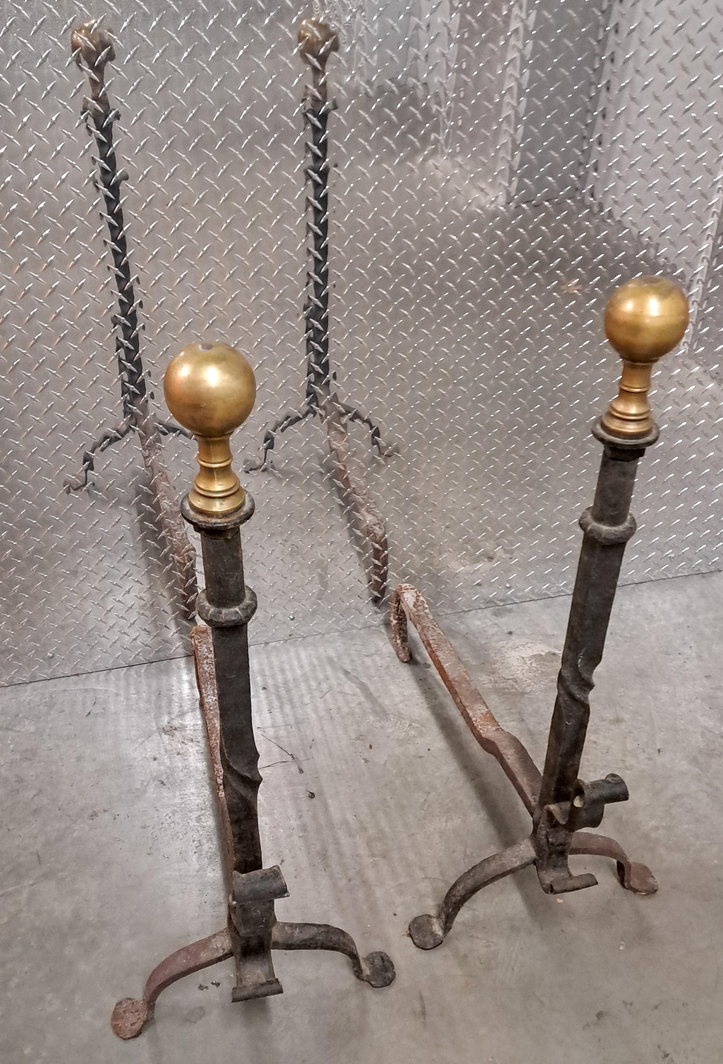 Pair of large majestic brass and wrought-iron andirons. Classic antique heavy fireplace accessory with brass accents. Finely crafted andirons will continue to age gracefully.